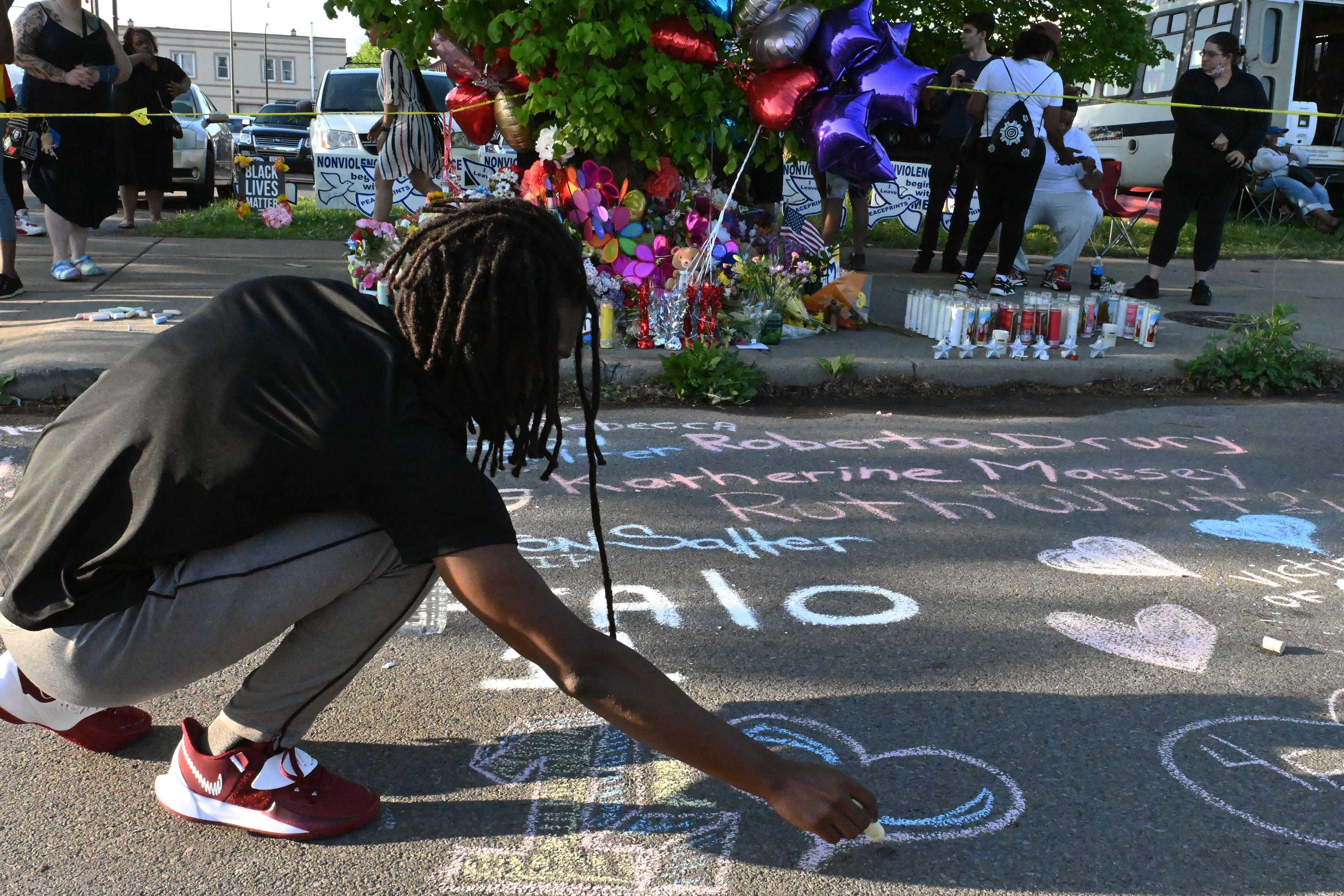 A mourner draws a heart with a piece of chalk during a vigil in Buffalo after a gunman killed 10 Black people in an attack motivated by racism. The New York education department canceled the history and government regents out of concerns some of the content would “compound student trauma” after the shooting.
