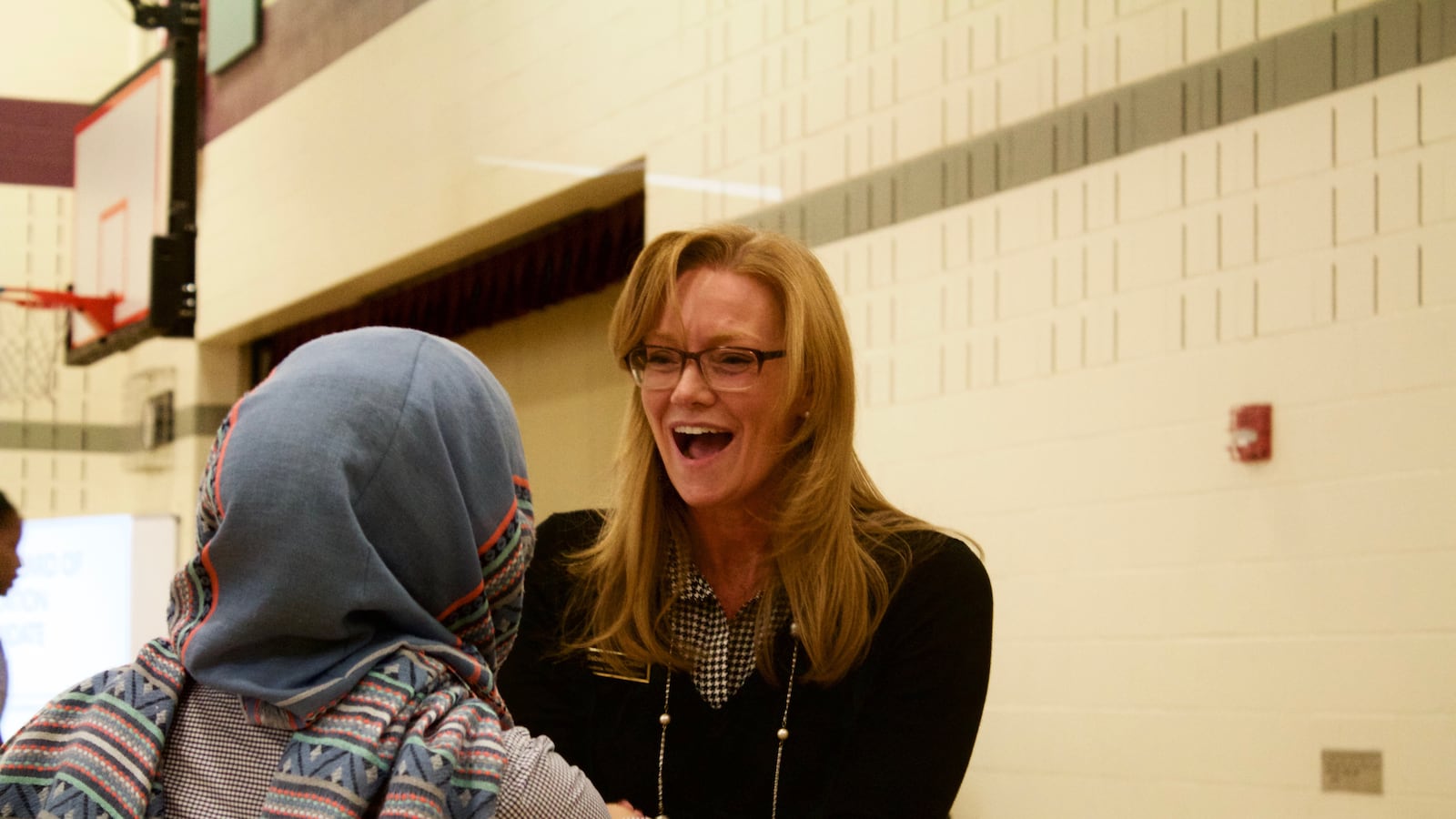 Rebecca McClellan, a candidate for the State Board of Education, greets a participant at a forum in Aurora.