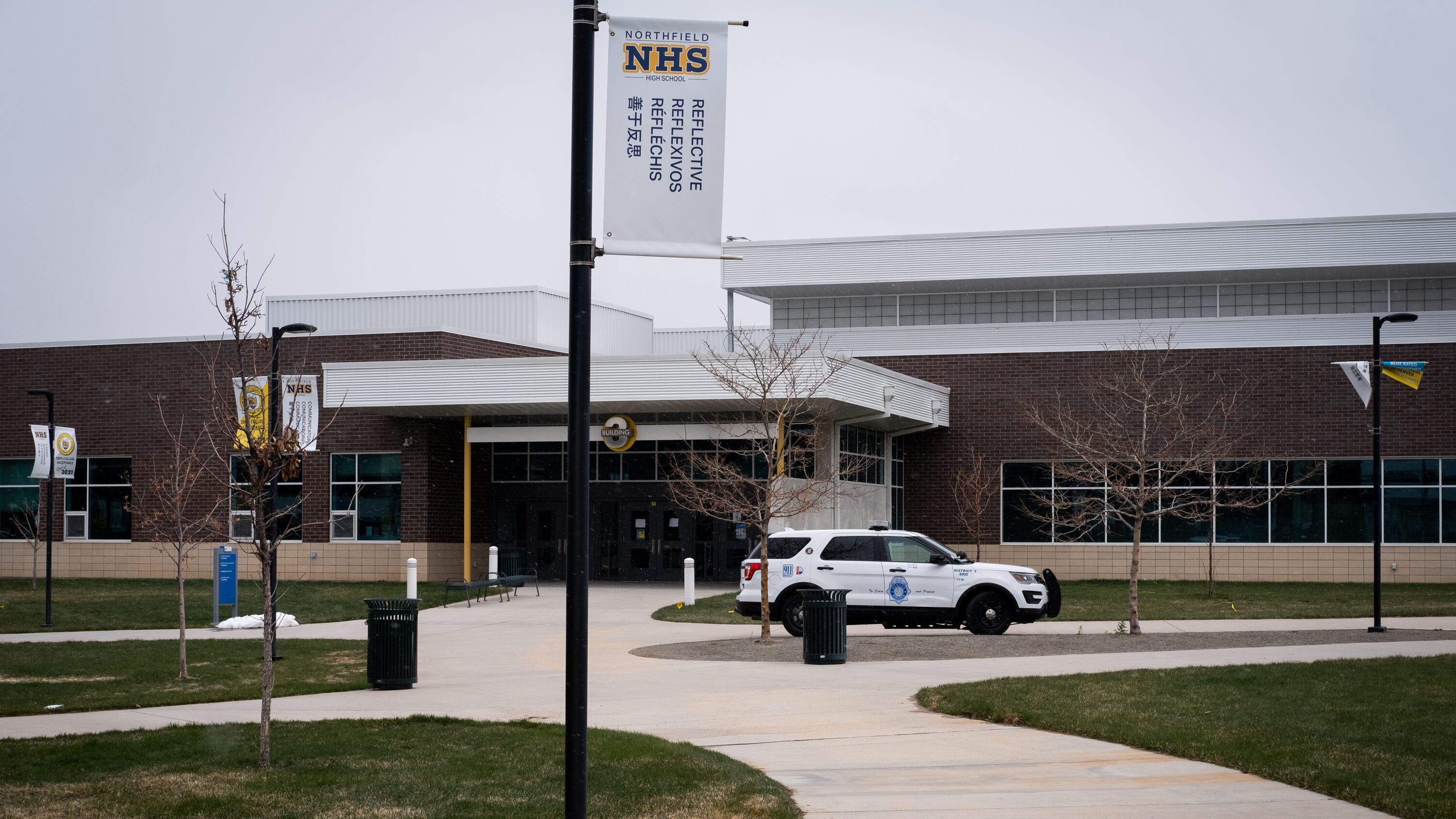 A police SUV sits outside a high school.