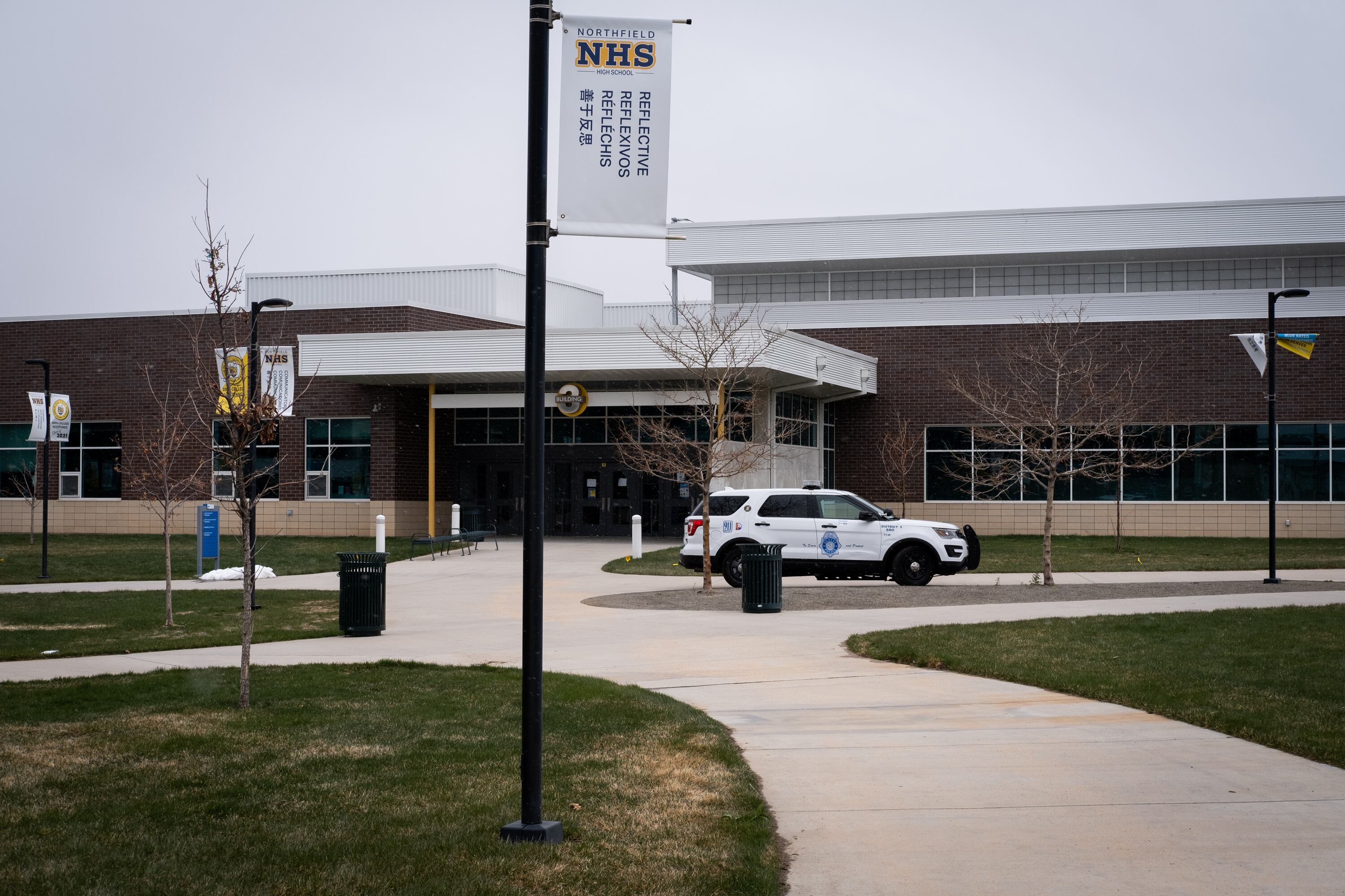 A police SUV sits outside a high school.