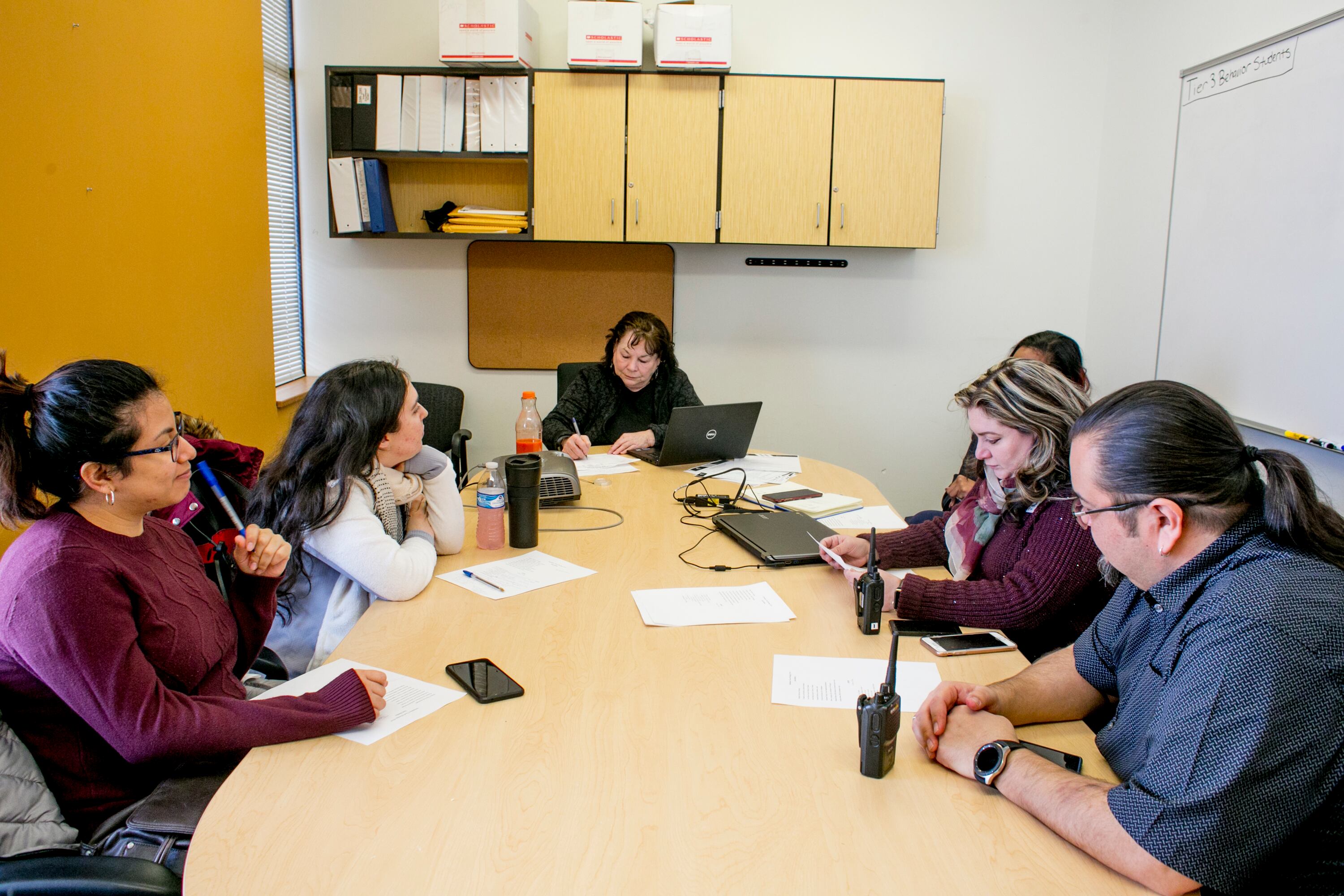 An attendance team meeting at Earhart Elementary-Middle School in southwest Detroit includes staff from the school and a community organization.