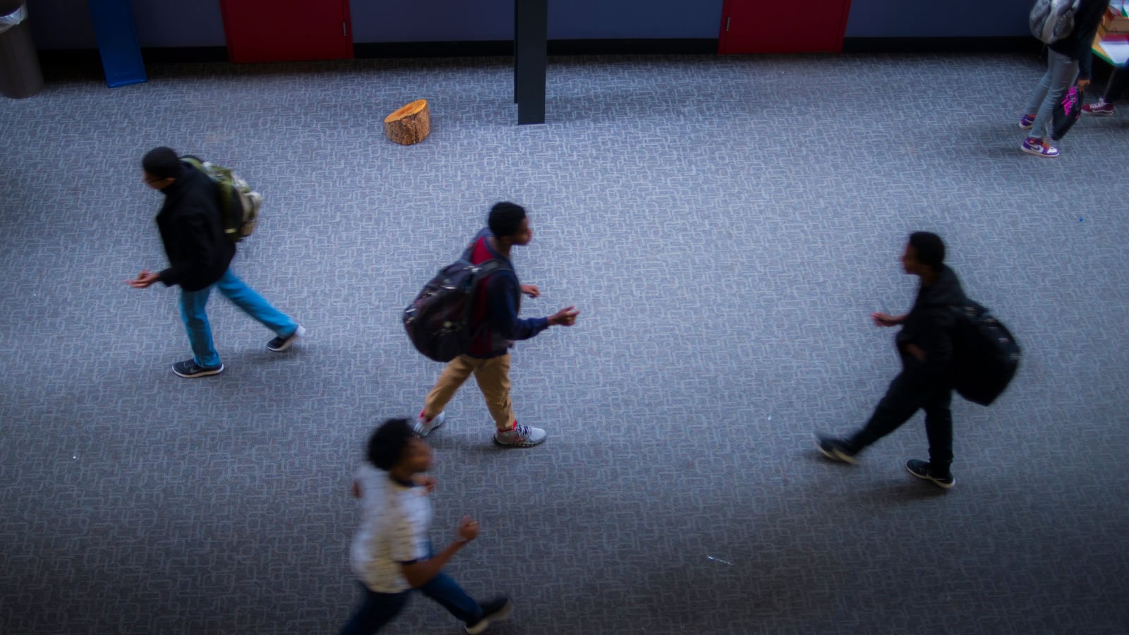 Students walk apart in a high school hallway.