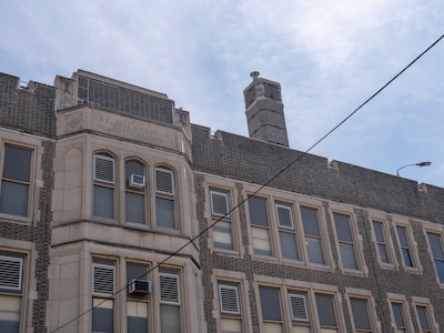 A portion of the top of a stone school building.