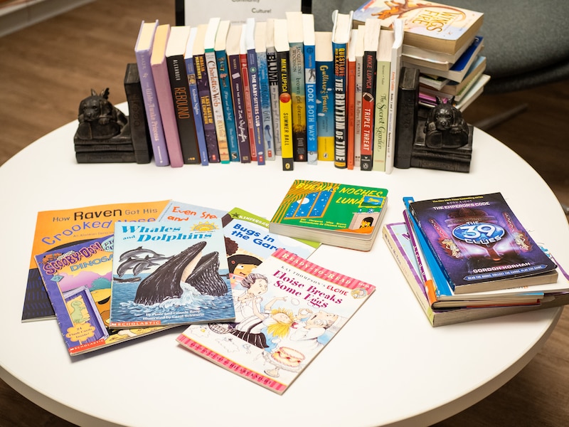 Children's books, including "Whales and Dolphins" and "Eloise breaks some eggs," are displayed on a table alongside other materials at the Yale Child Study Center children’s library.