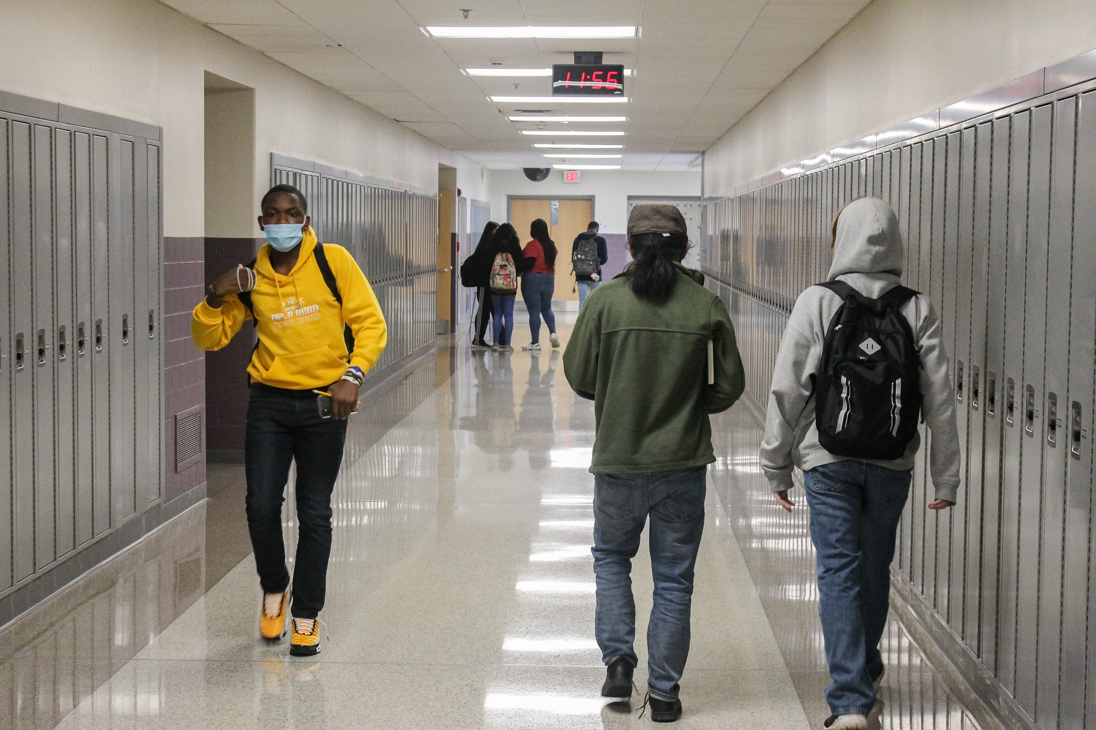 Three students walk in a hallway lined with lockers at Ben Davis High School in Indianapolis, Ind. on April 9, 2021.