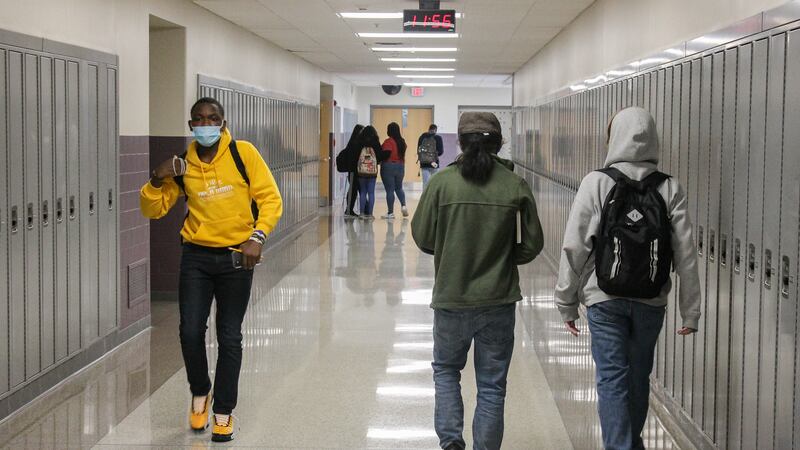 Three students walk in a hallway lined with lockers at Ben Davis High School in Indianapolis, Ind. on April 9, 2021.
