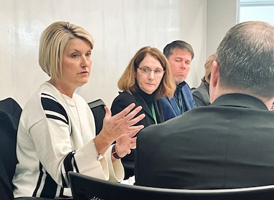Four people sit at a table talking.