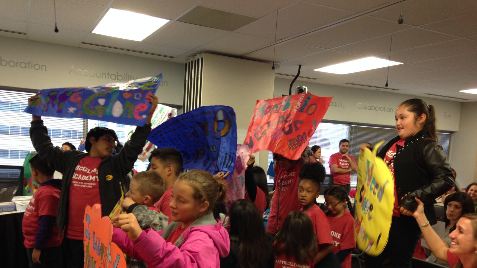 McGlone students hold signs in support of expansion at a recent school board meeting.