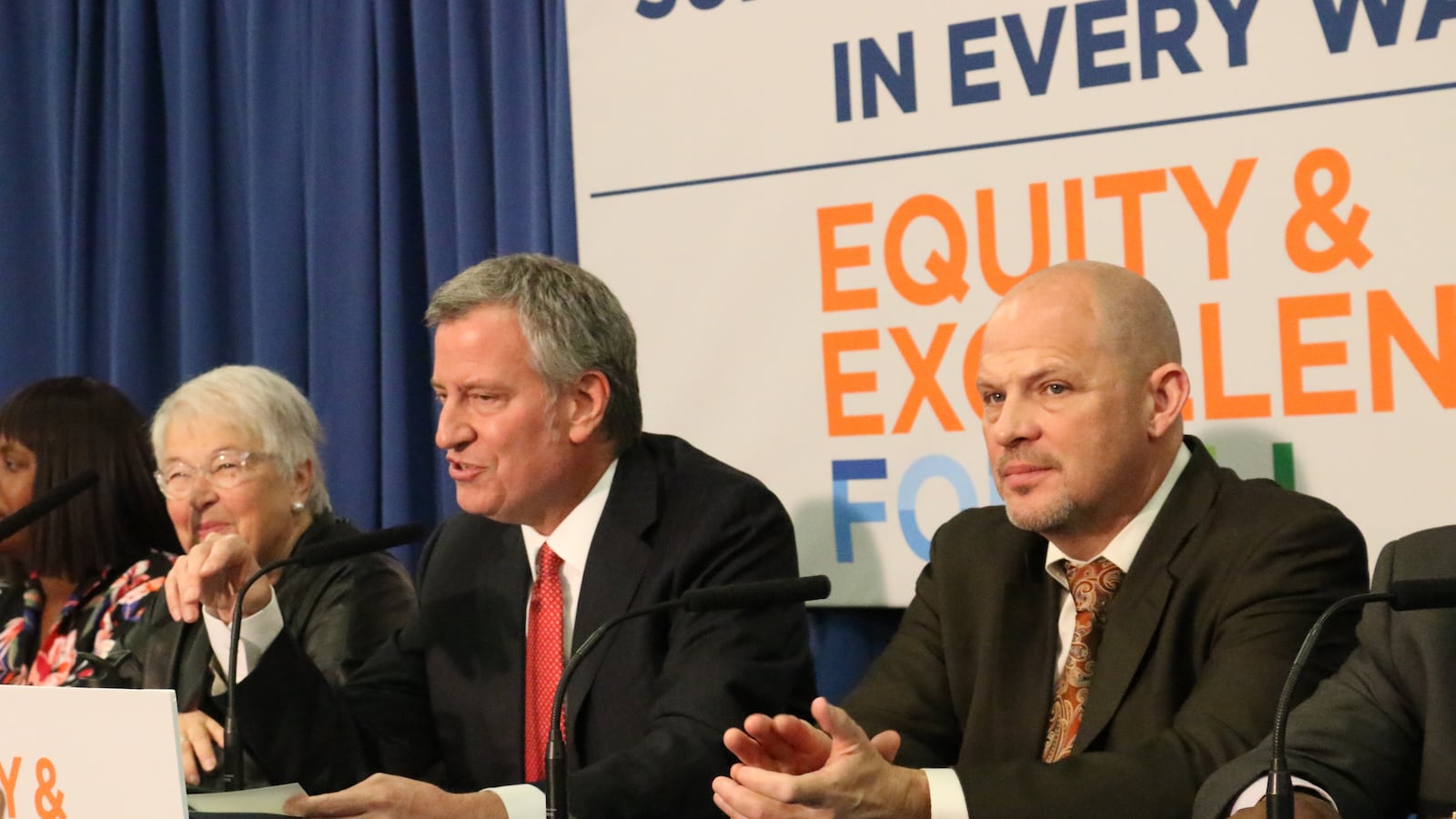 United Federation of Teachers President Michael Mulgrew, right, says the union is negotiating with Mayor Bill de Blasio, center, for a paid family leave policy.