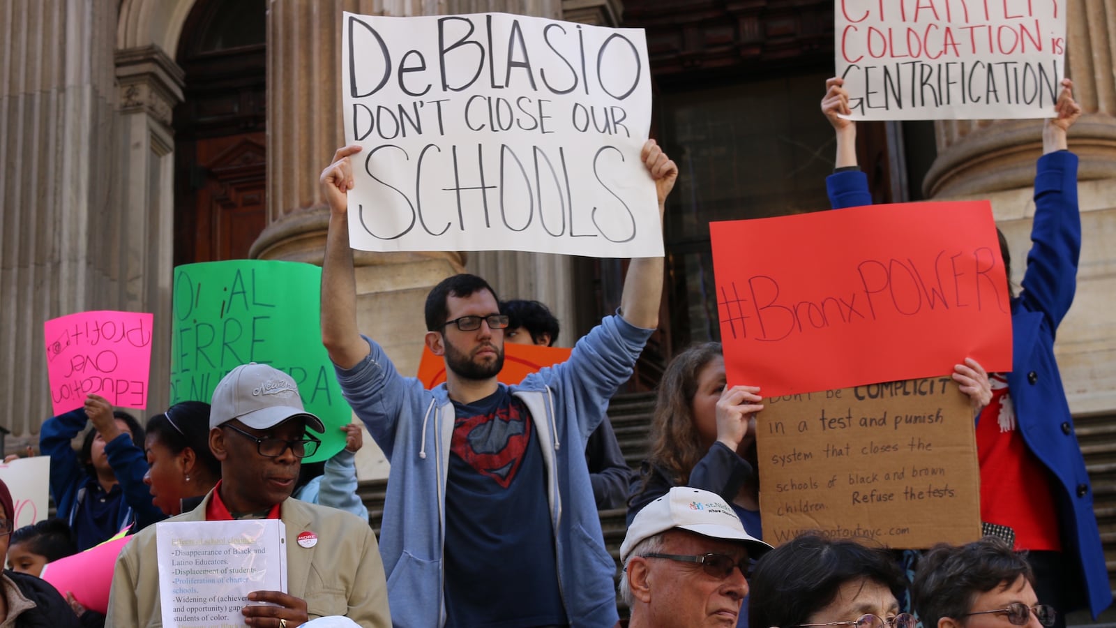 Protesters gathered at the education department's headquarters to protest a previous set of closure plans.