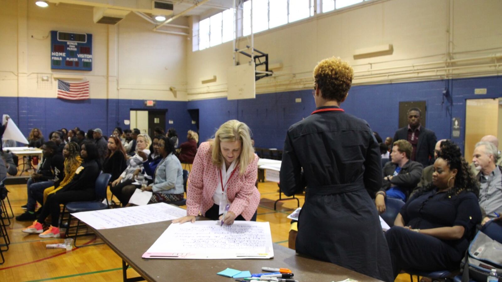 Eve Carney, the state's chief district officer, writes down audience answers during the listening tour stop in Frayser.