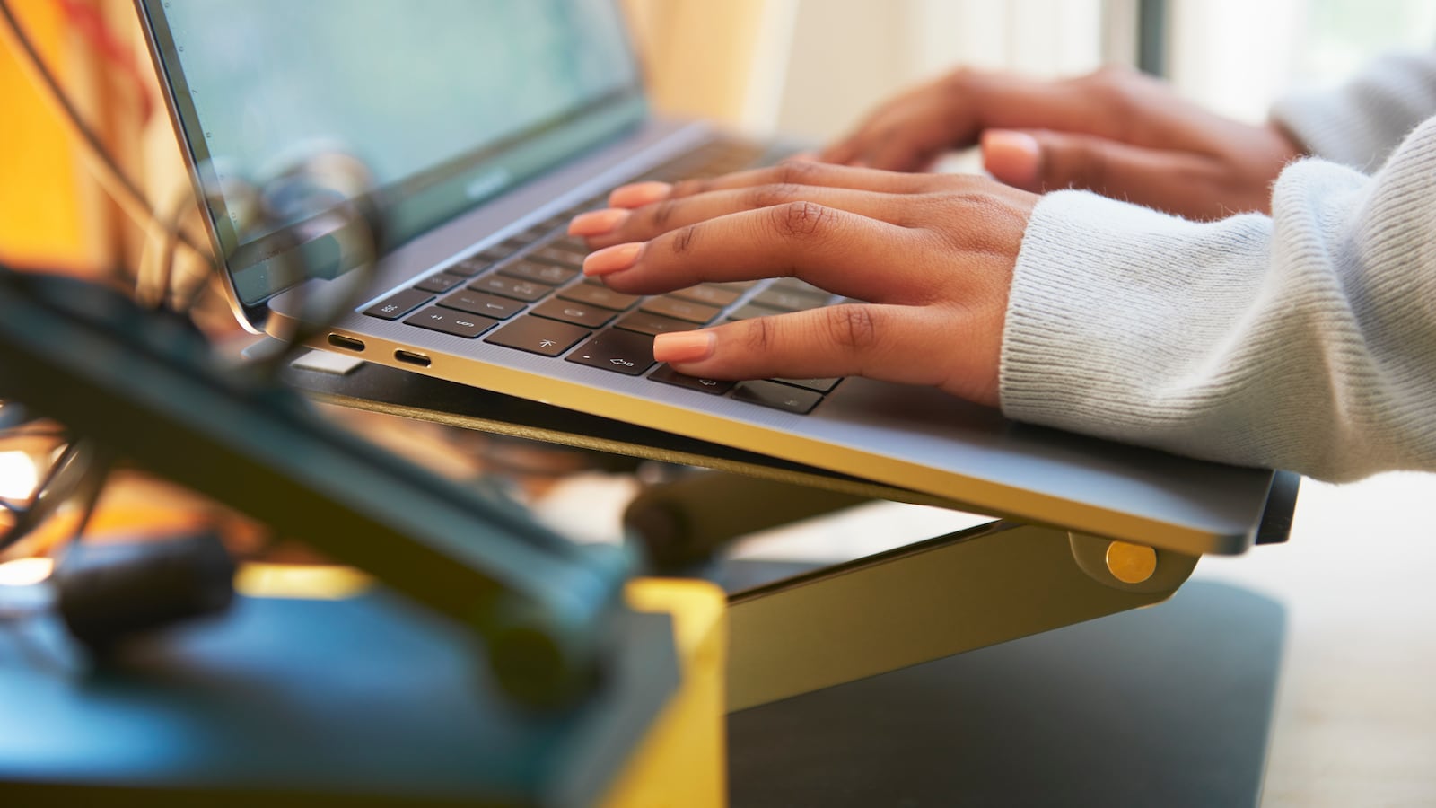 Close up of a pair of hands typing on a laptop keyboard.