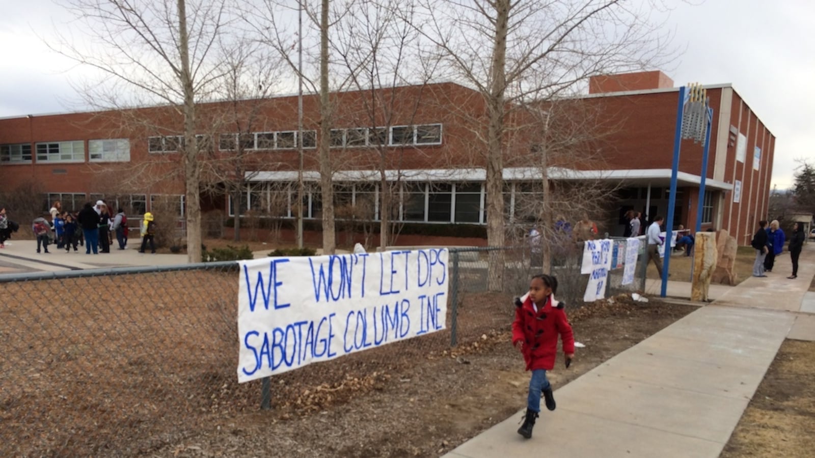 A Columbine Elementary School student runs past a protest sign made my parents. Denver Public Schools told Columbine principal Beth Yates she wouldn't be returning as the school's leader next year. Parents and teachers want to know why. A district official was supposed to meet with teachers Thursday, but canceled and asked to reschedule.