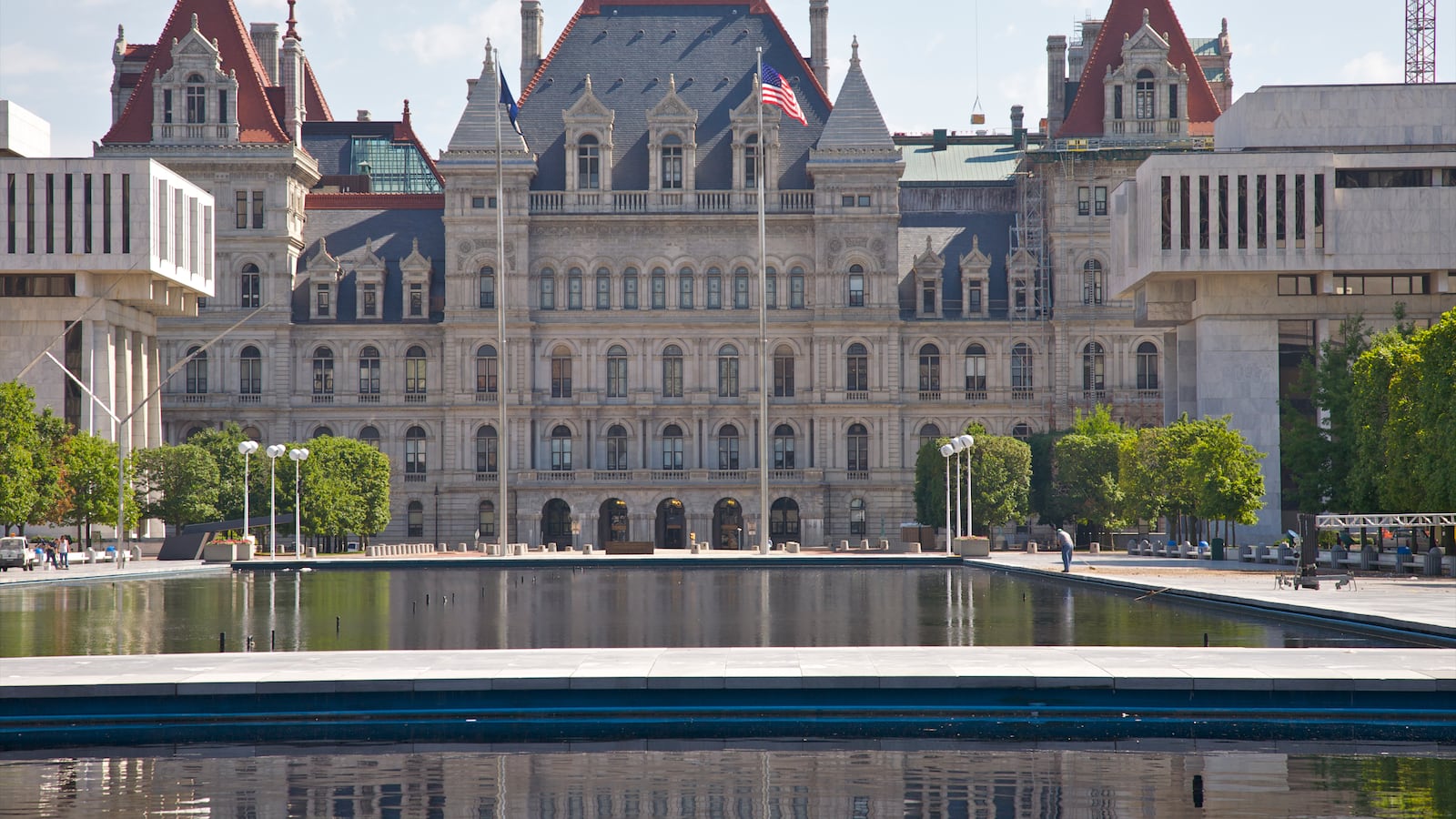 The exterior of the New York State Capitol with a pond in the foreground.