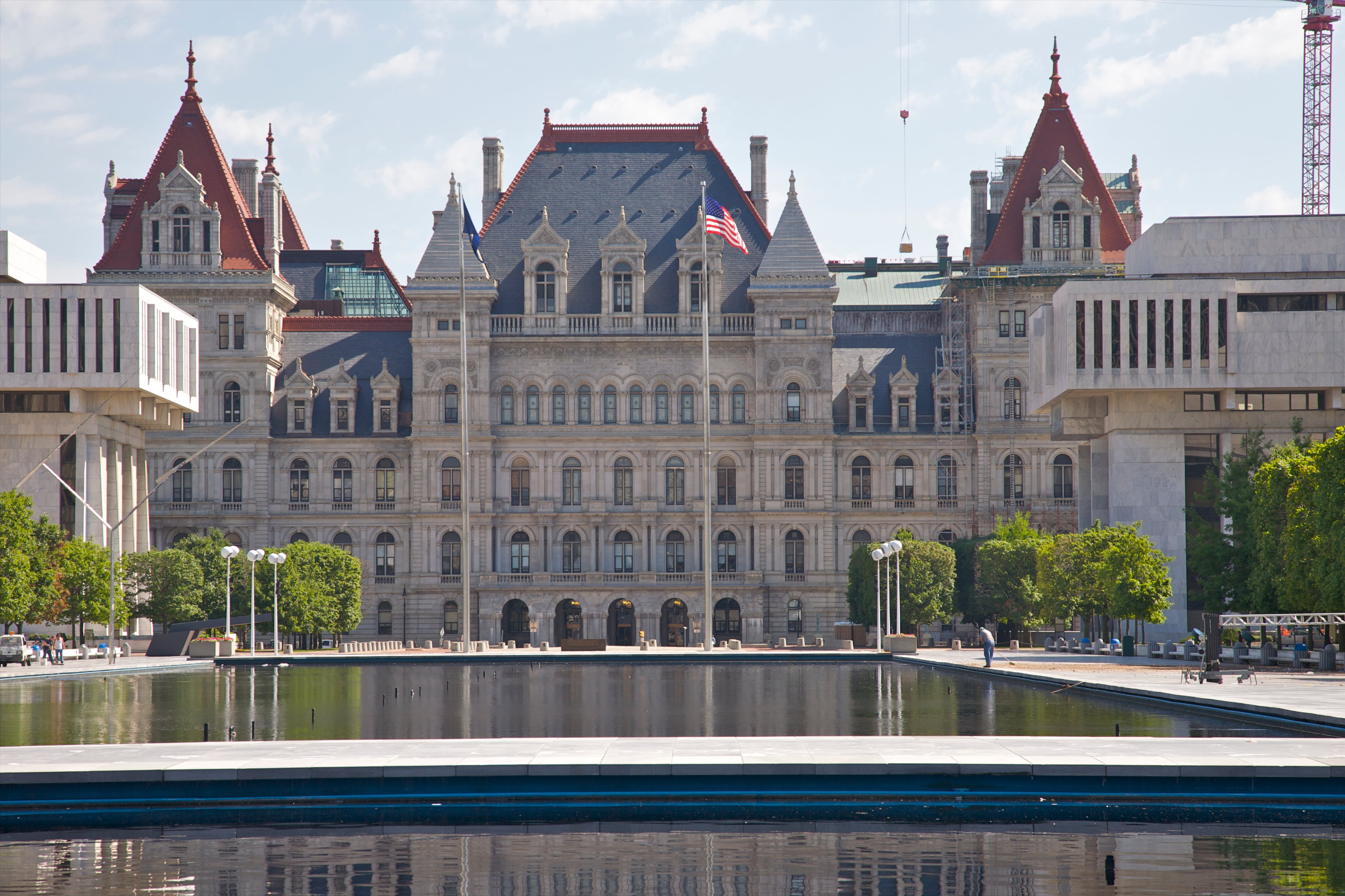 The exterior of the New York State Capitol with a pond in the foreground.