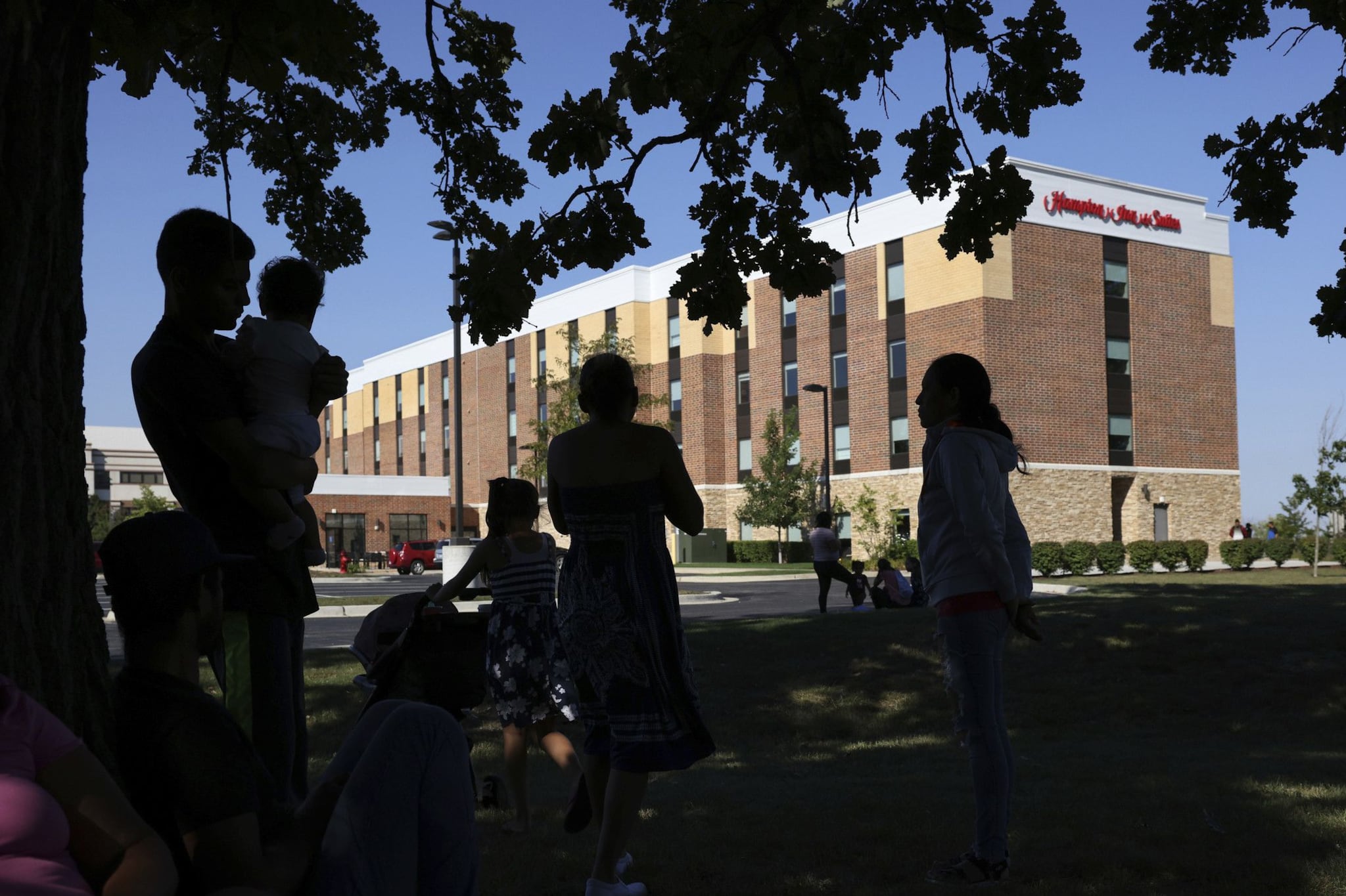 Migrants from Venezuela stand outside of a hotel in suburban Burr Ridge, Illinois.