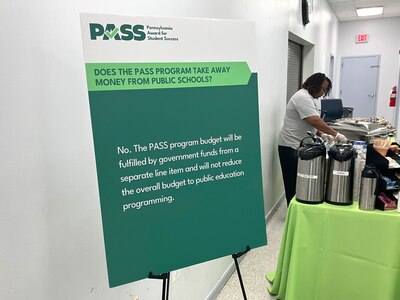 A green poster with white letters sits in a community center room.