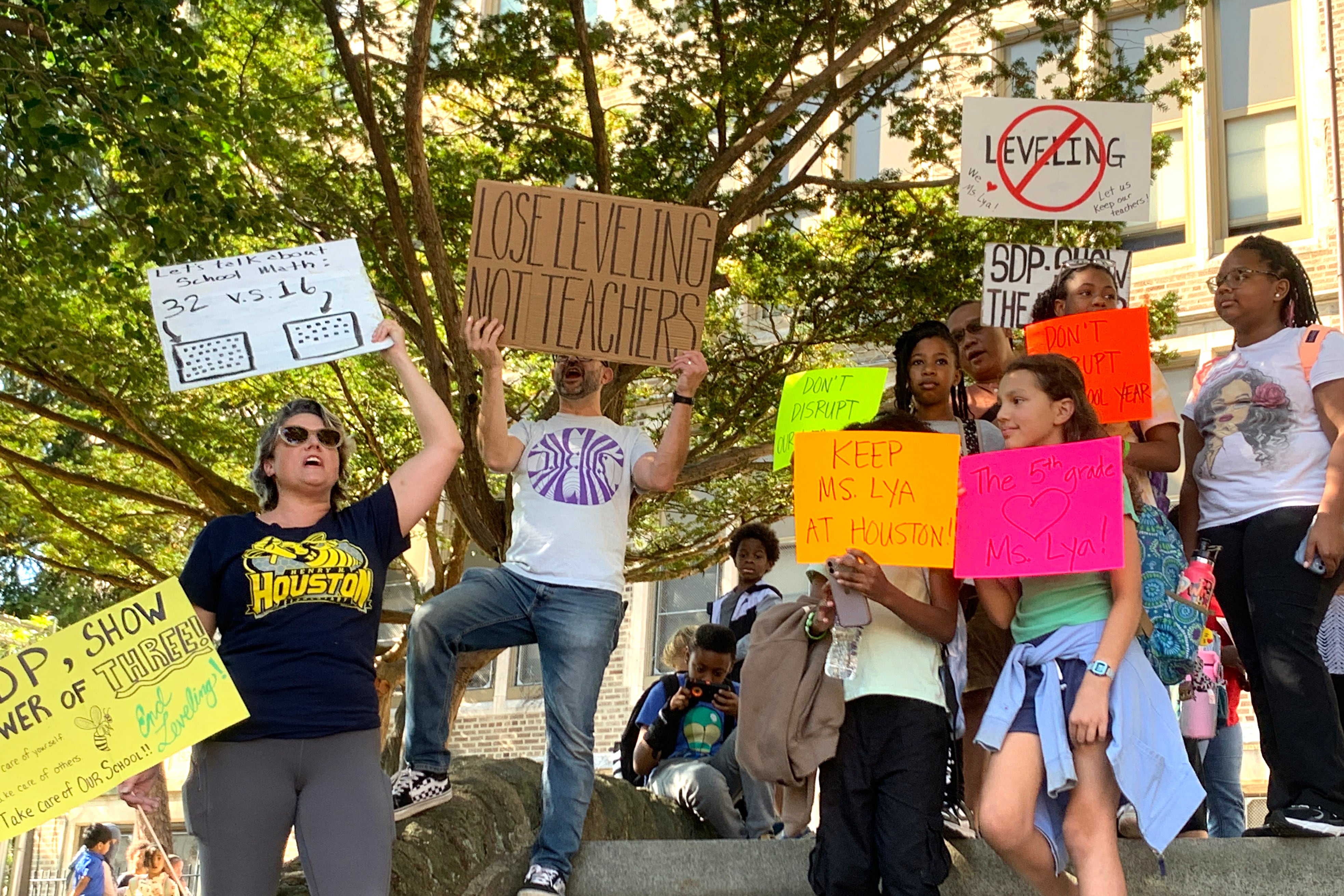 A group of people hold signs on stone steps