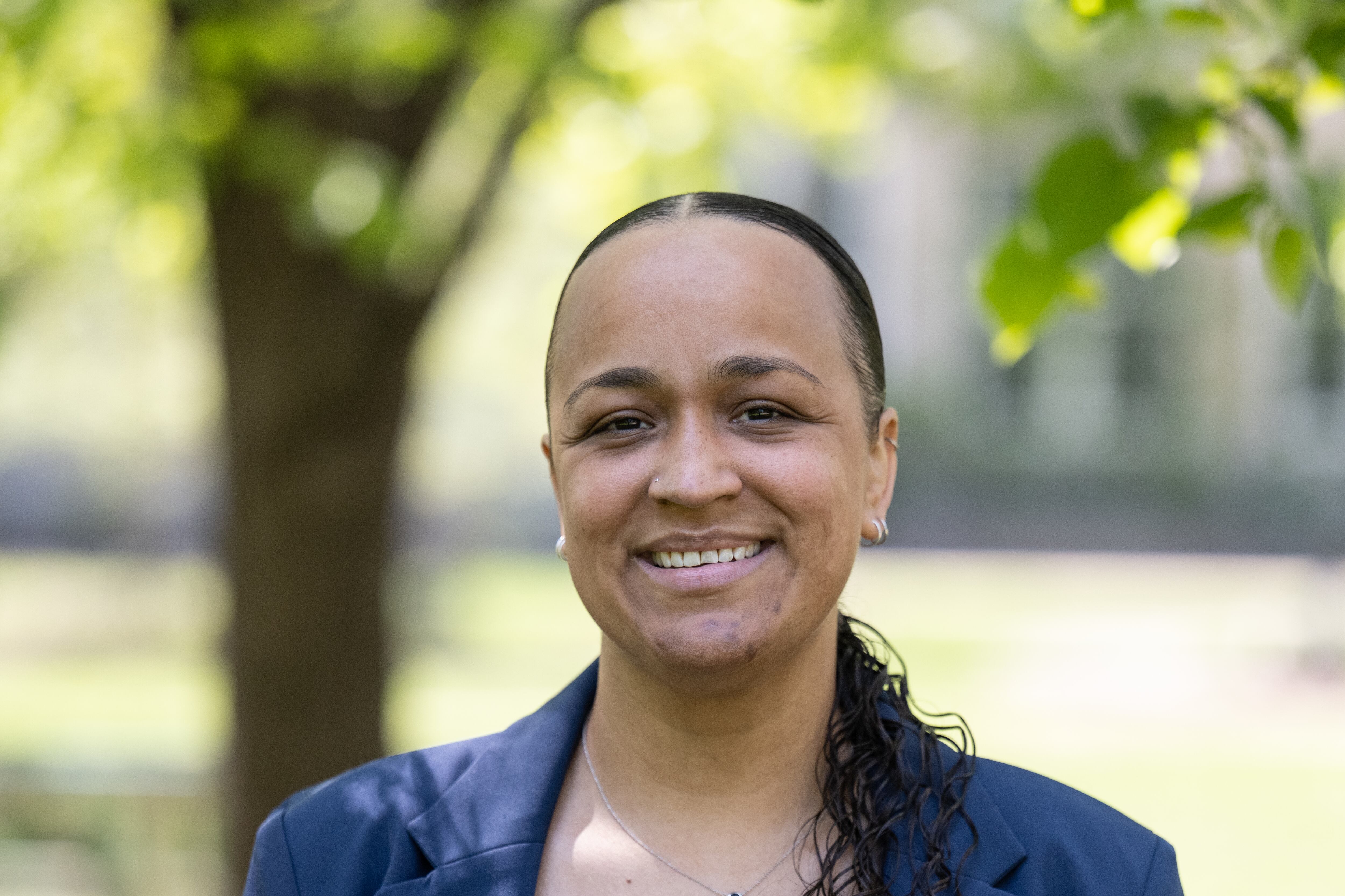 A woman in a blue jacket and top smiles for the camera.