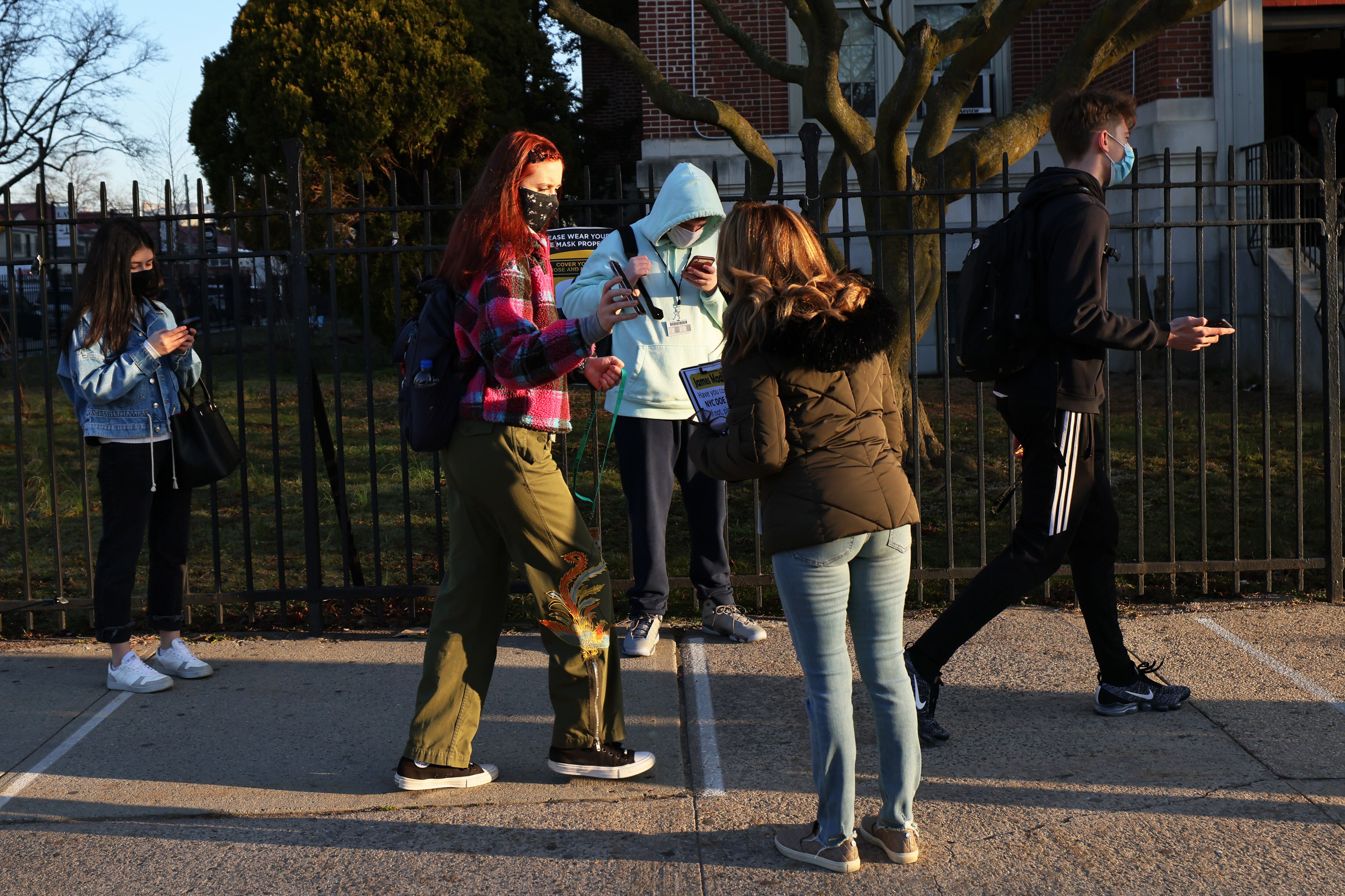 NEW YORK, NEW YORK - MARCH 22: School officials welcome students at James Madison High School on March 22, 2021 in the Madison neighborhood of the Brooklyn borough in New York City. High schools throughout New York City opened today for the first time since being closed in November due to a rise in coronavirus (COVID-19) positive cases.