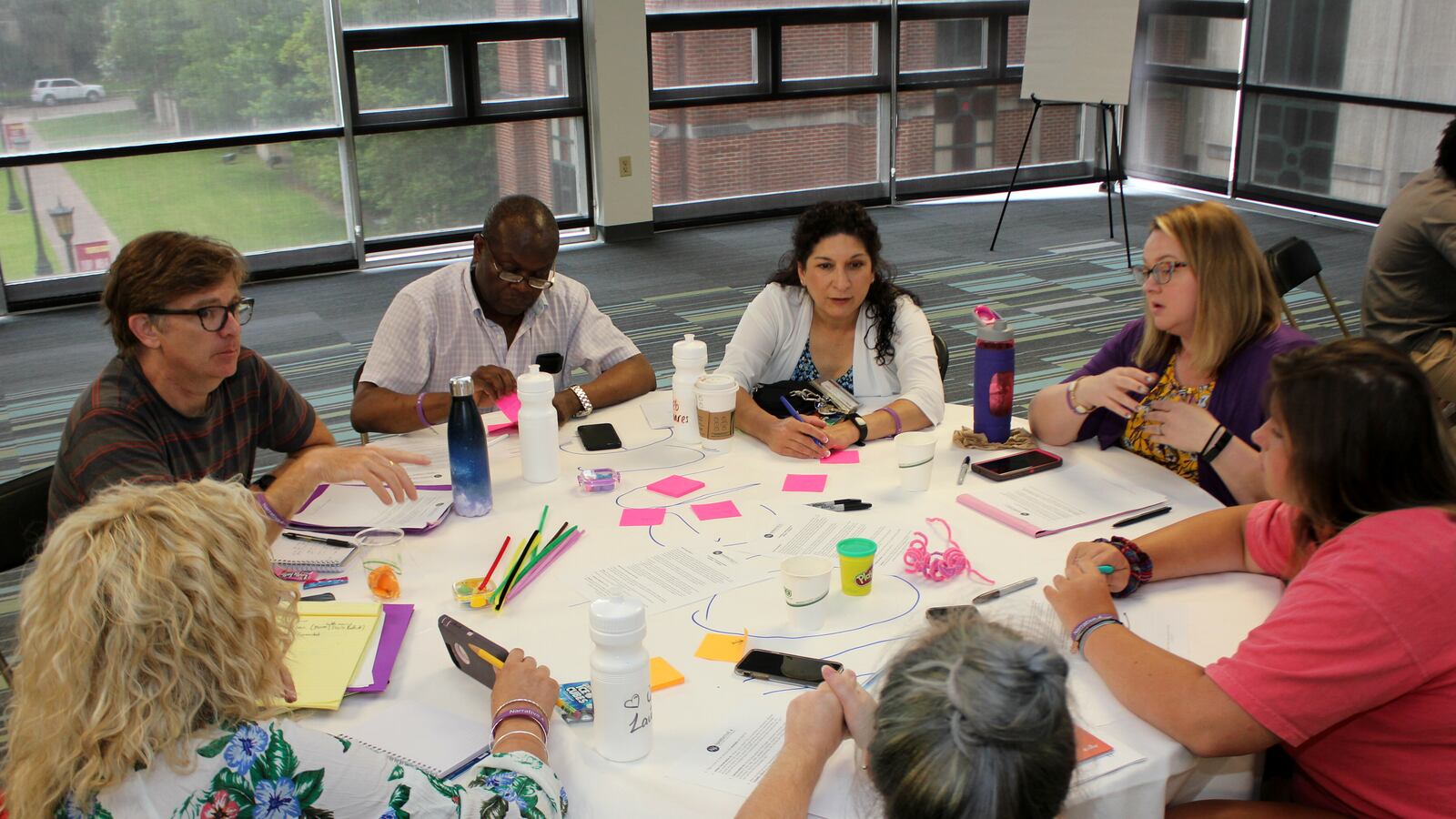 A group of teachers sit at a table and participate in a story exchange