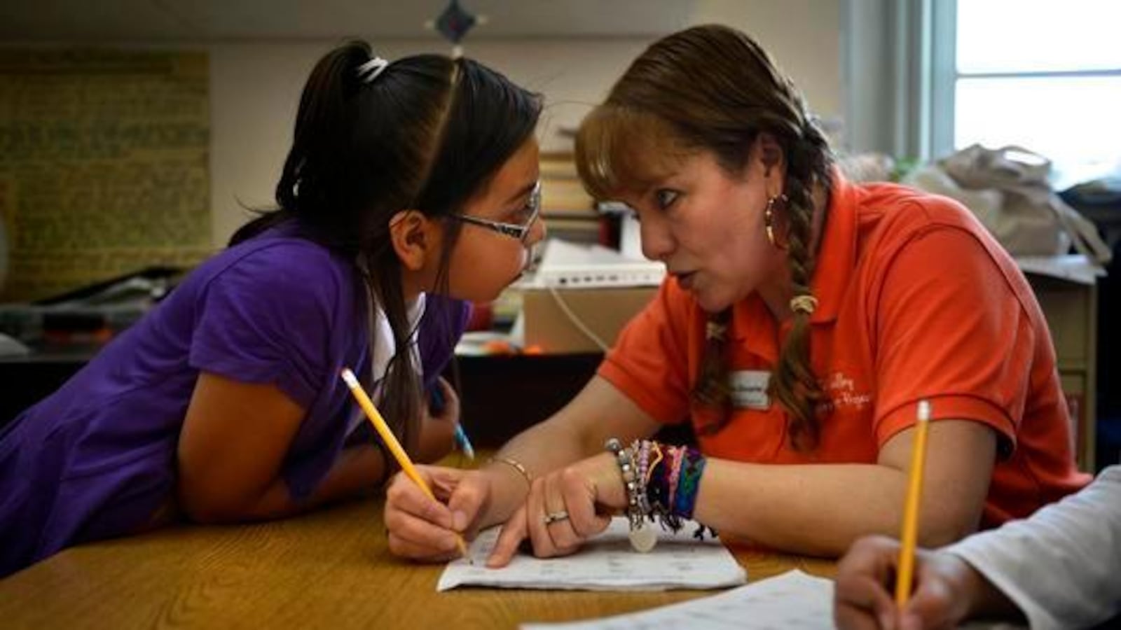 A parent mentor helps a student with a math problem at Crystal River Elementary School in Carbondale in 2013.