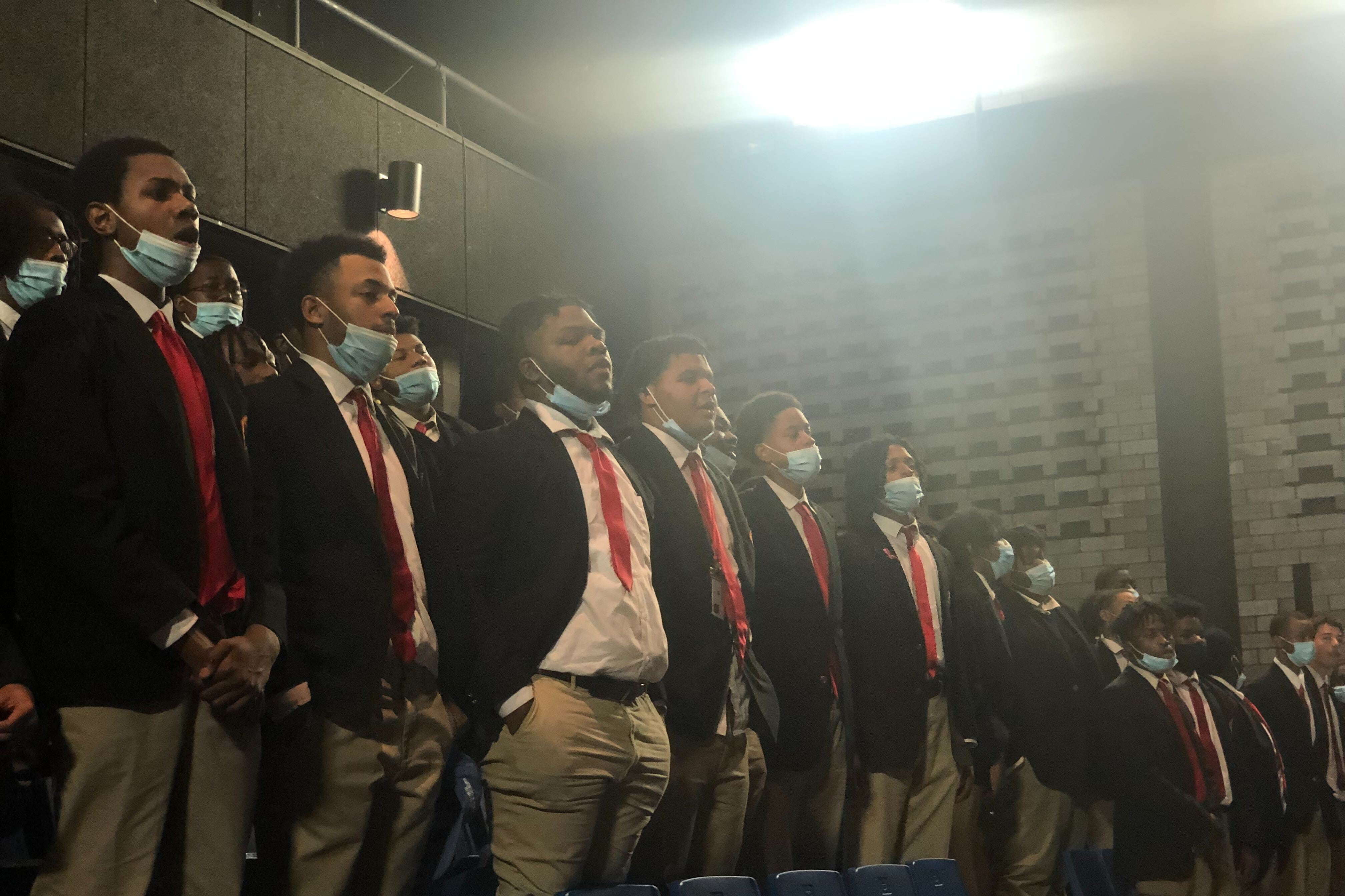 Students in uniform stand in an auditorium at a charter school in Englewood.