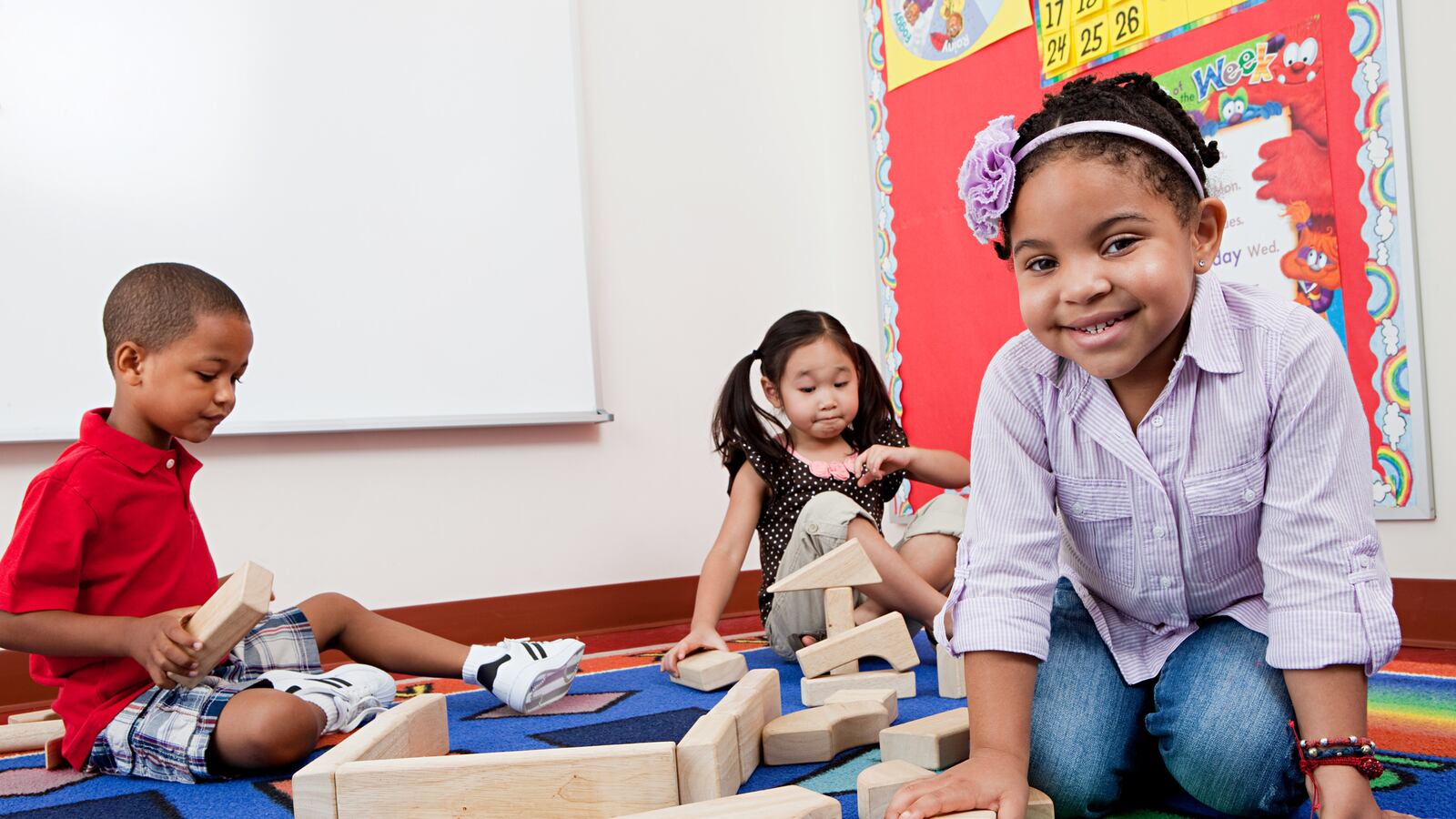 Children on floor with building blocks. (Image Source | Getty Images)