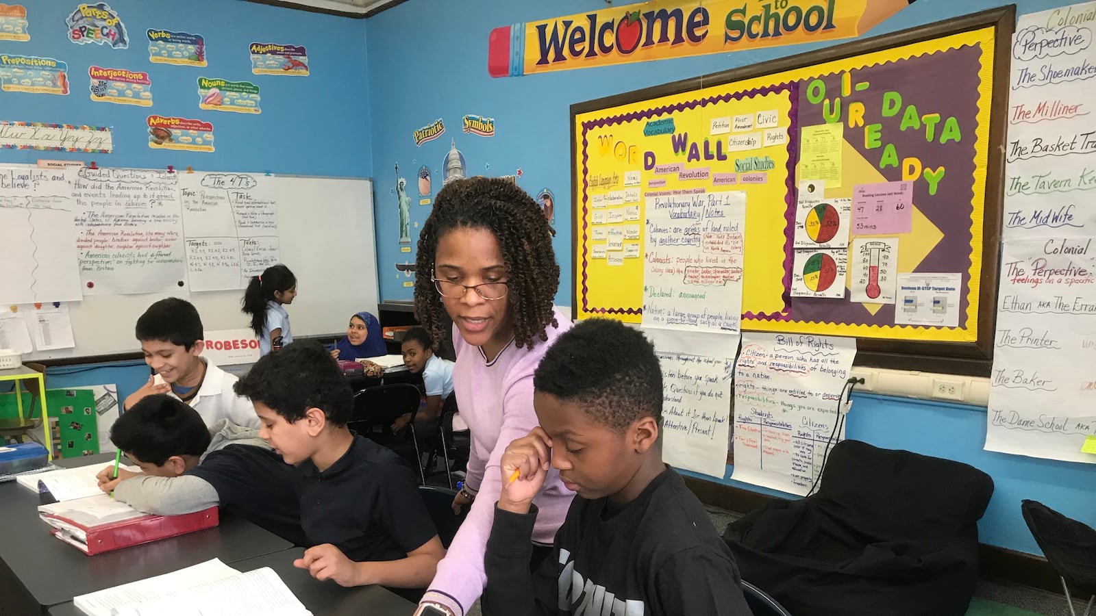 Kenya Posey, who teaches fourth-grade English language arts and social studies, works with students during a recent lesson.