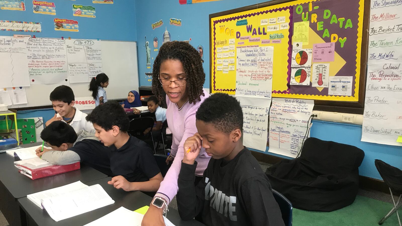 Kenya Posey, who teaches fourth-grade English language arts and social studies, works with students during a recent lesson.