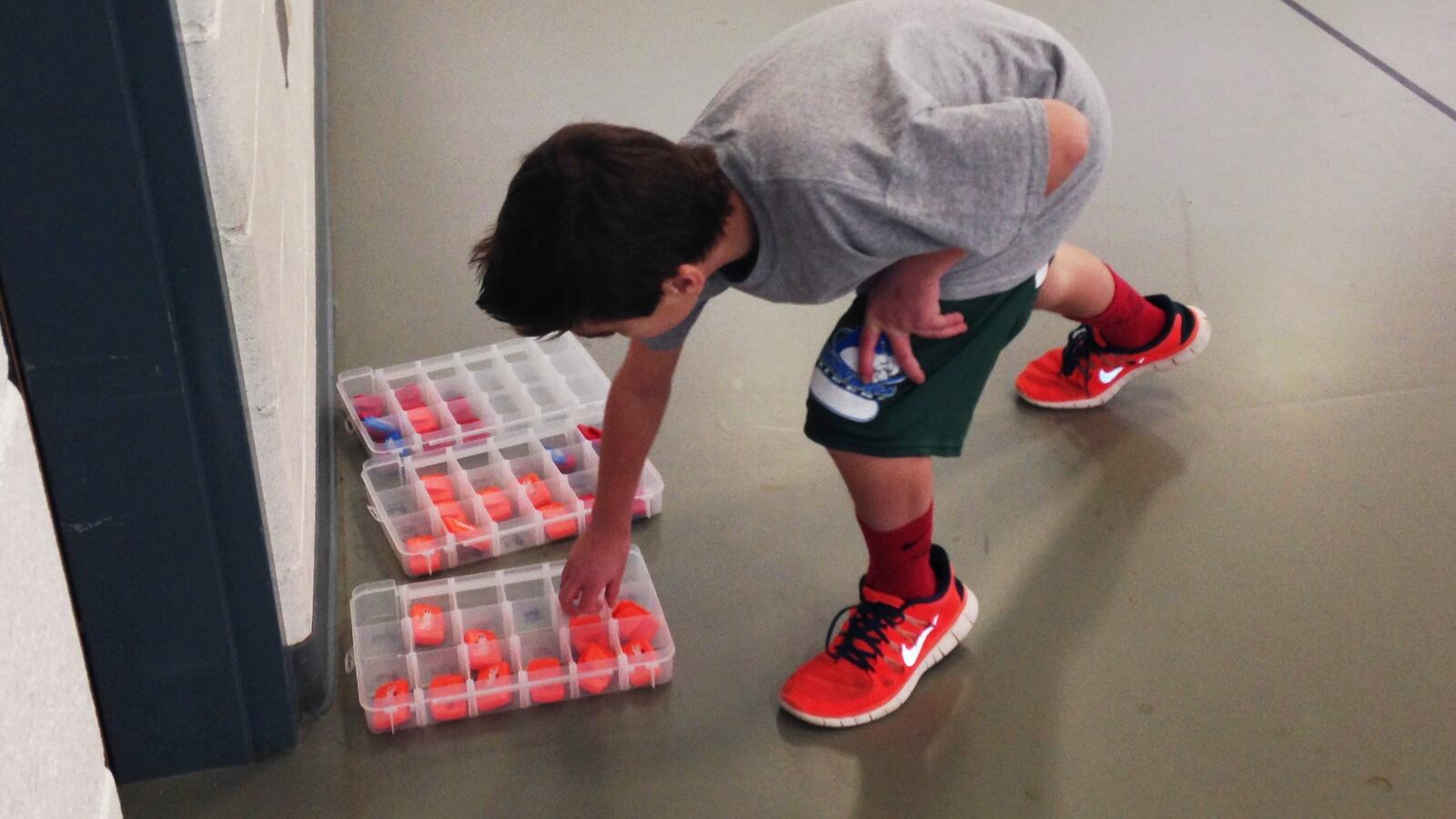 A student at Falcon Bluffs Middle School in Jefferson County picks up his pedometer before P.E. class.