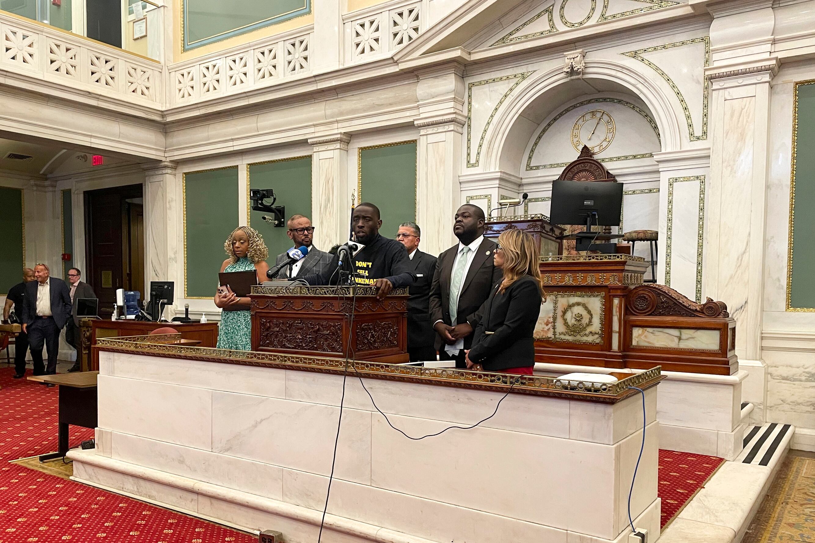 A group of people standing at the podium, speaking.