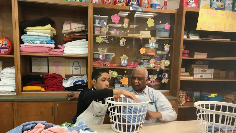 A Charles R. Drew Transition Center student practices folding laundry as his teacher looks on at the special education school in Detroit