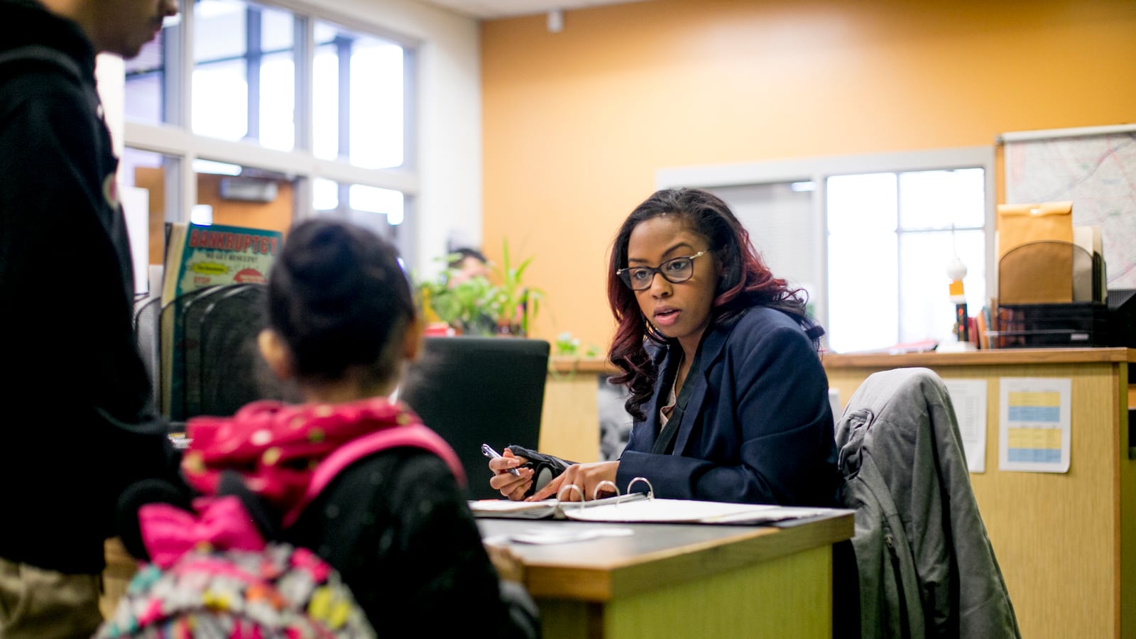 Attendance agent Amanda Bowman signs in students who arrive late for class at Earhart Elementary Middle School in southwest Detroit