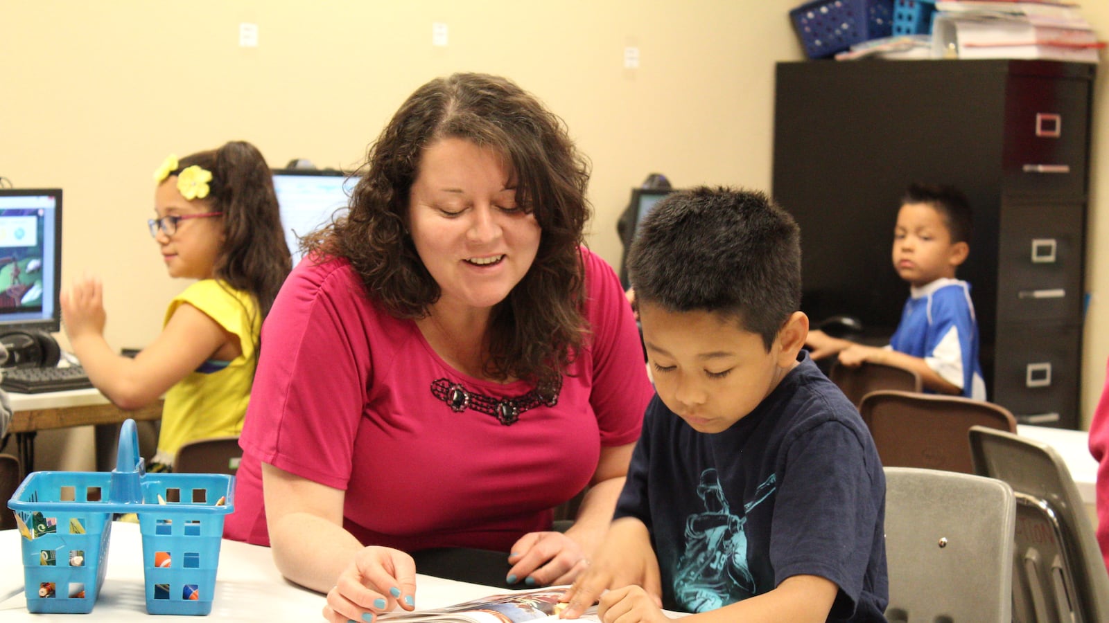 Ana Gramajo, left, is the co-director of HOPE Online Action Academy in Aurora. Here she works with a student on reading.