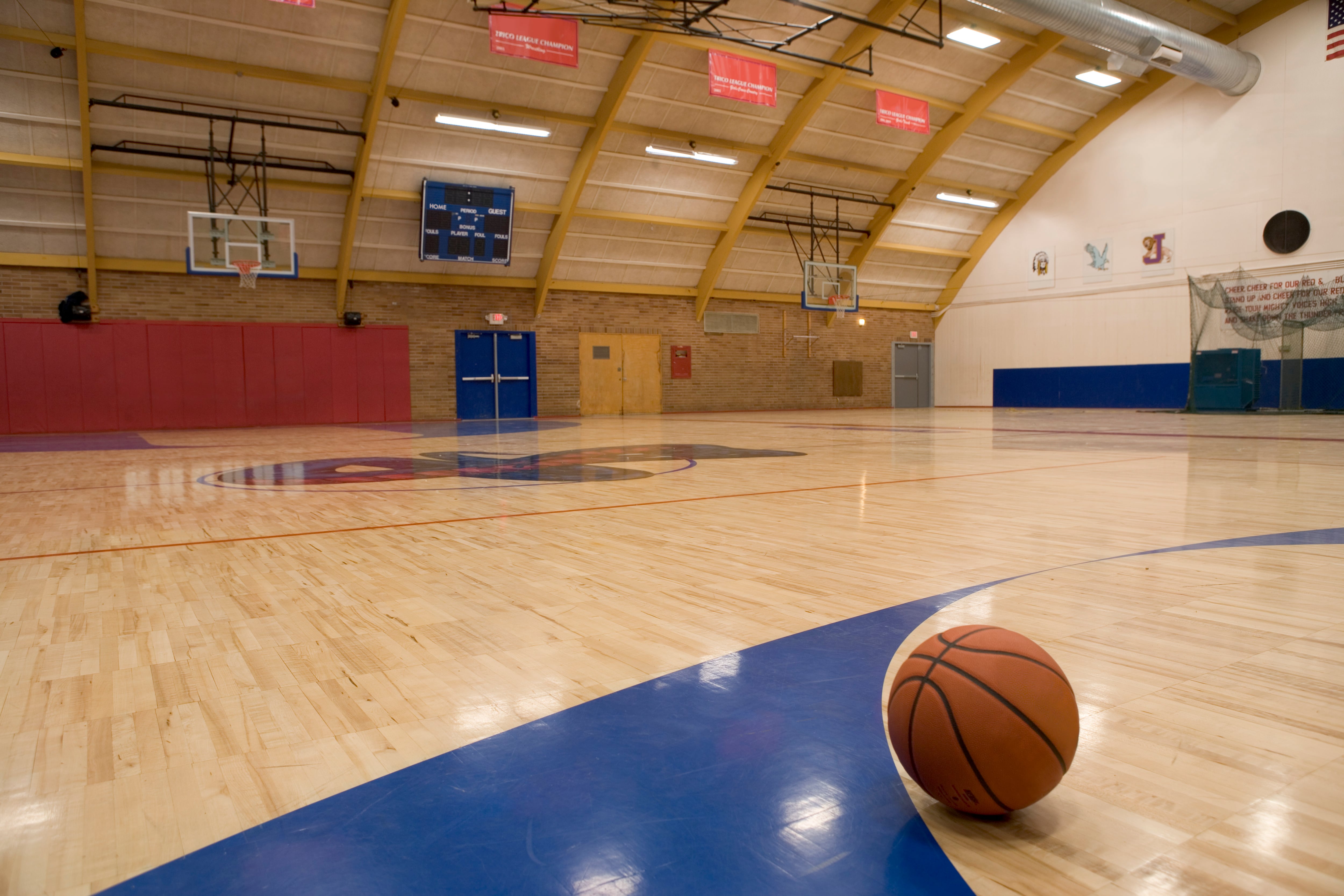 A basketball on a gym floor.