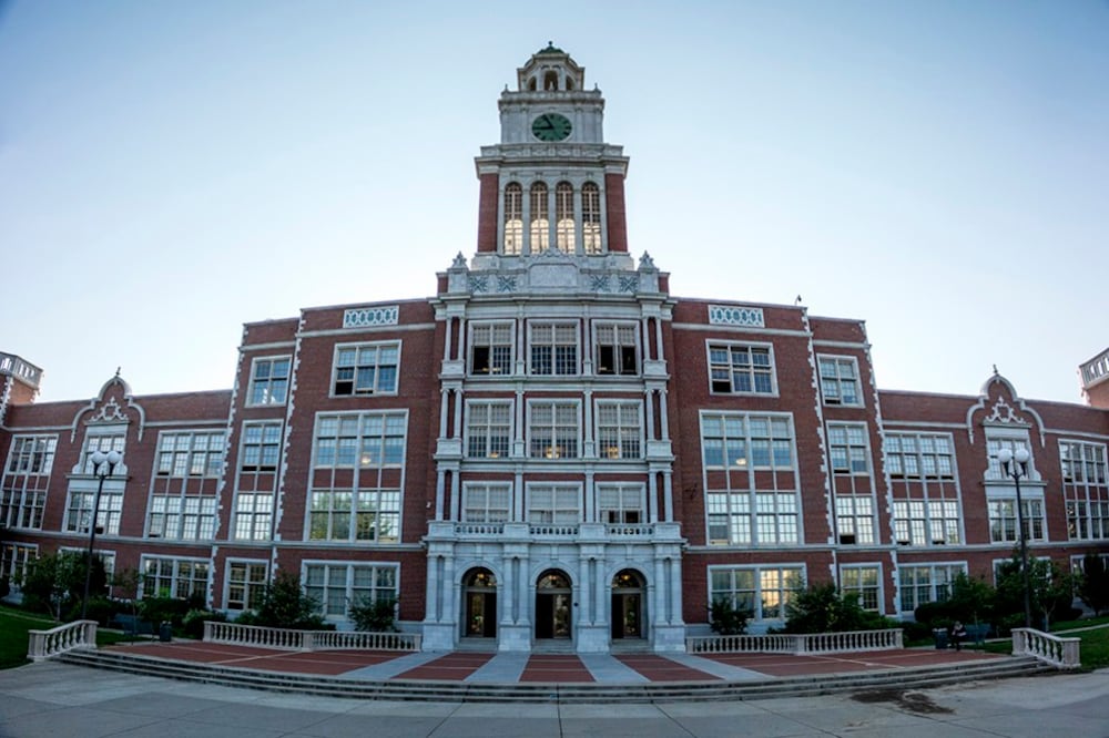 The outside of East High School. It is a stately brick building with lots of windows and a clocktower.