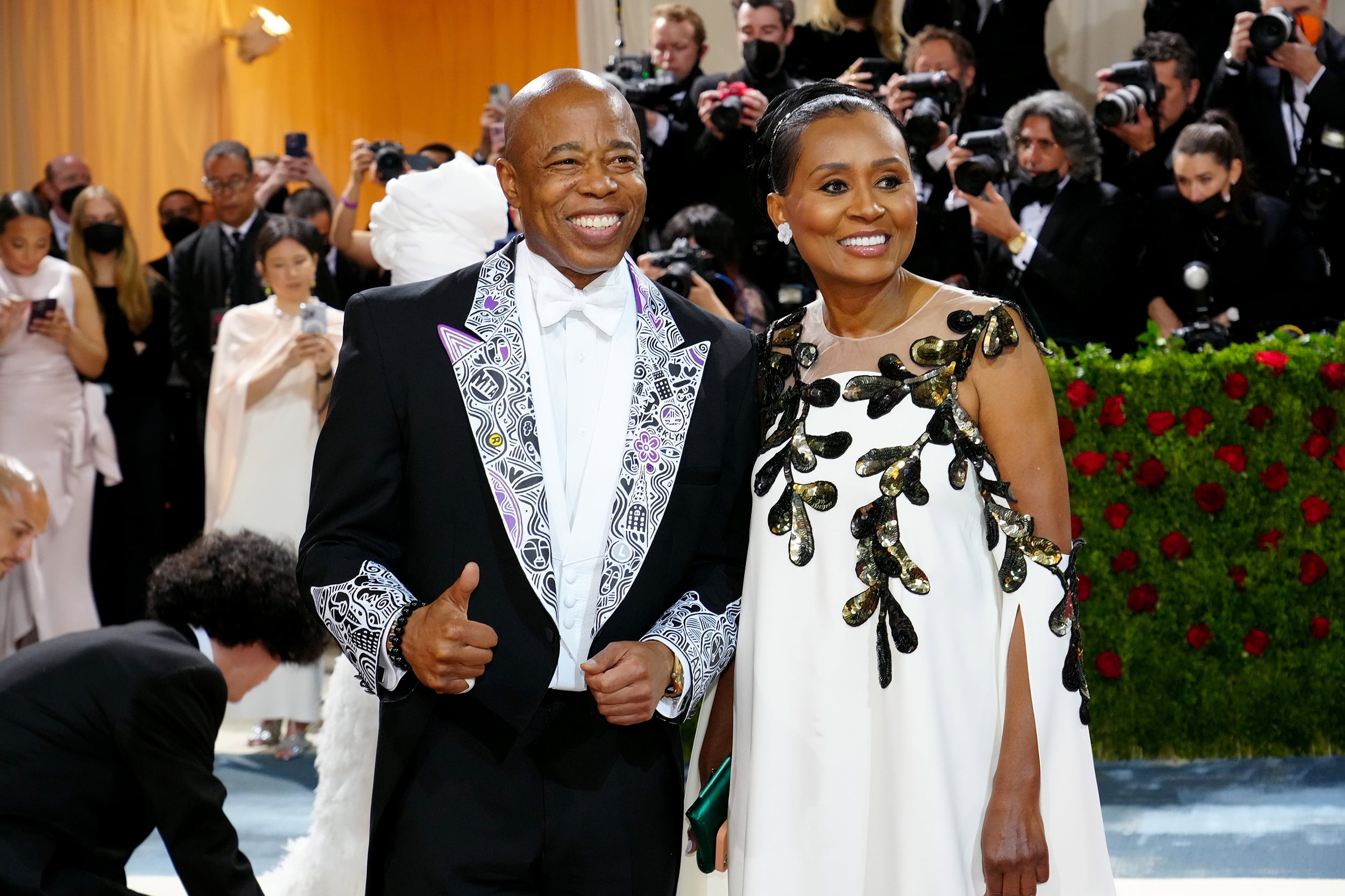 Two people in formal wear stand next to each other.