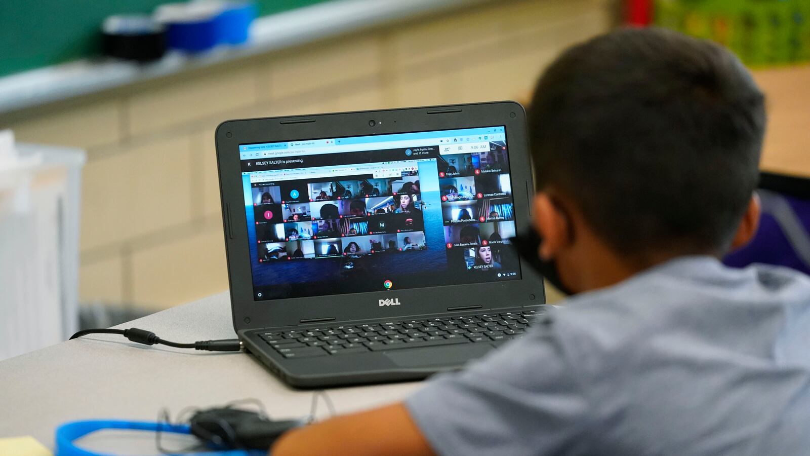 Boy participates in a video lesson on his laptop in a learning center.