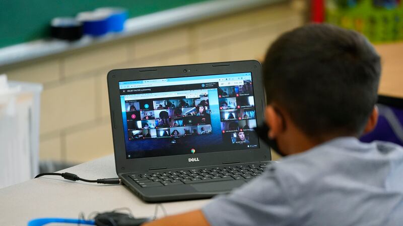 Boy participates in a video lesson on his laptop in a learning center.