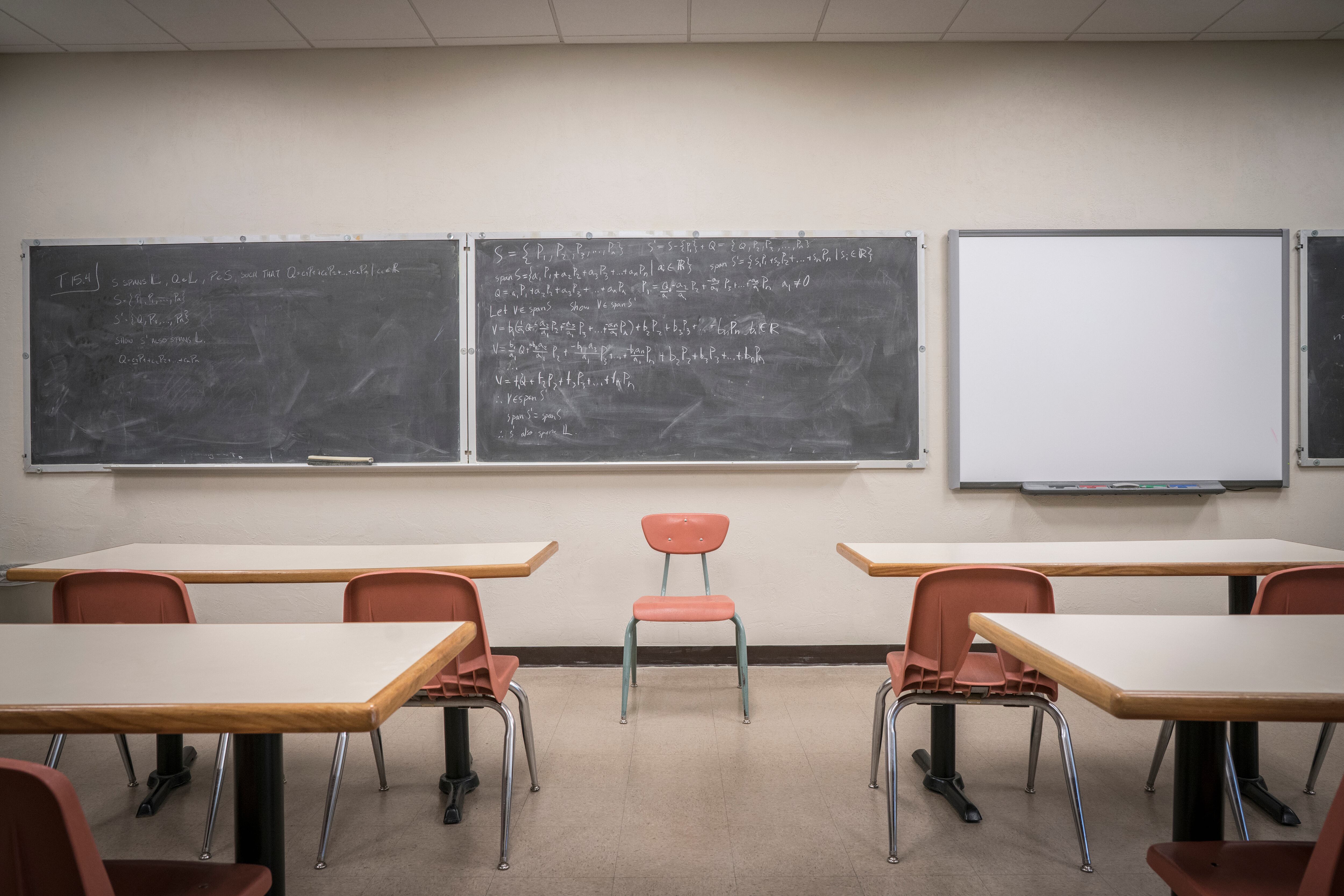 A classroom sits empty with equation on the blackboard