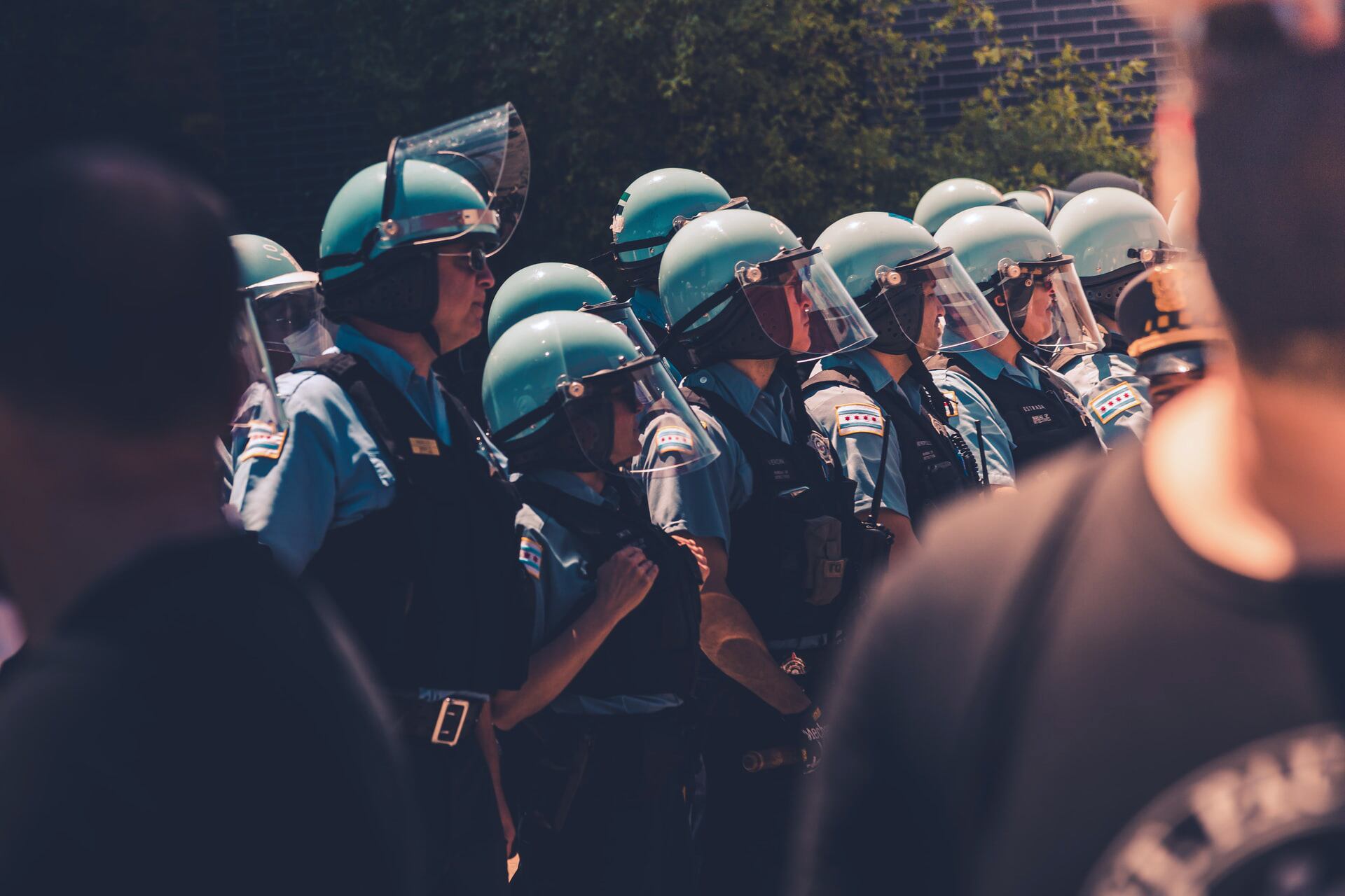 Group of police officers wearing uniforms and face shields.