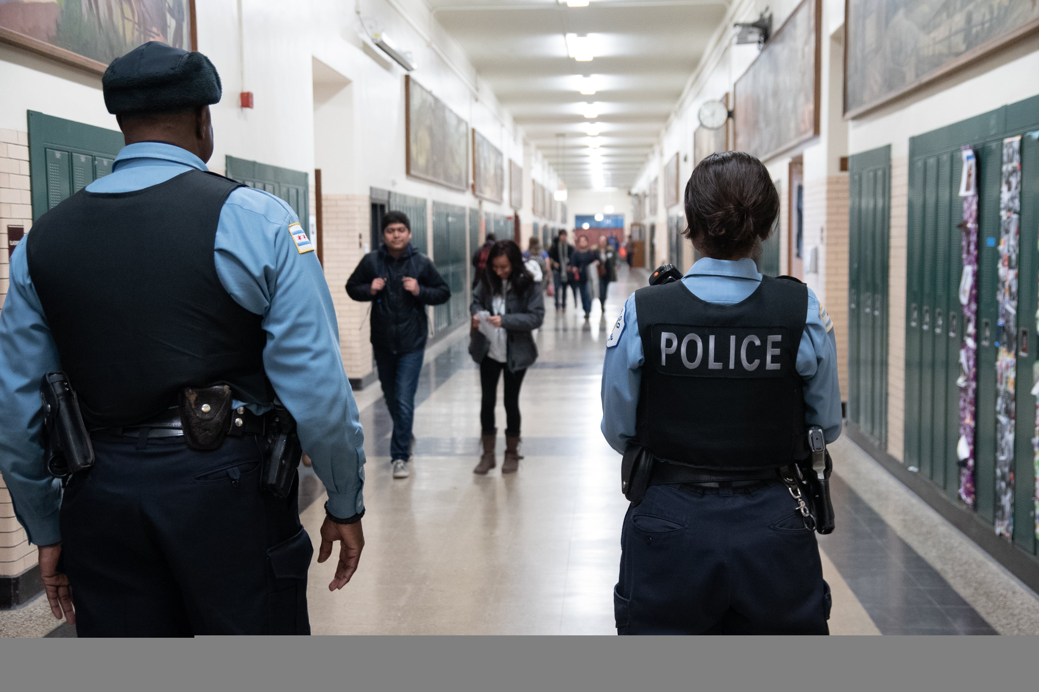Campus police officers walk the halls of Lane Tech High School in Chicago.