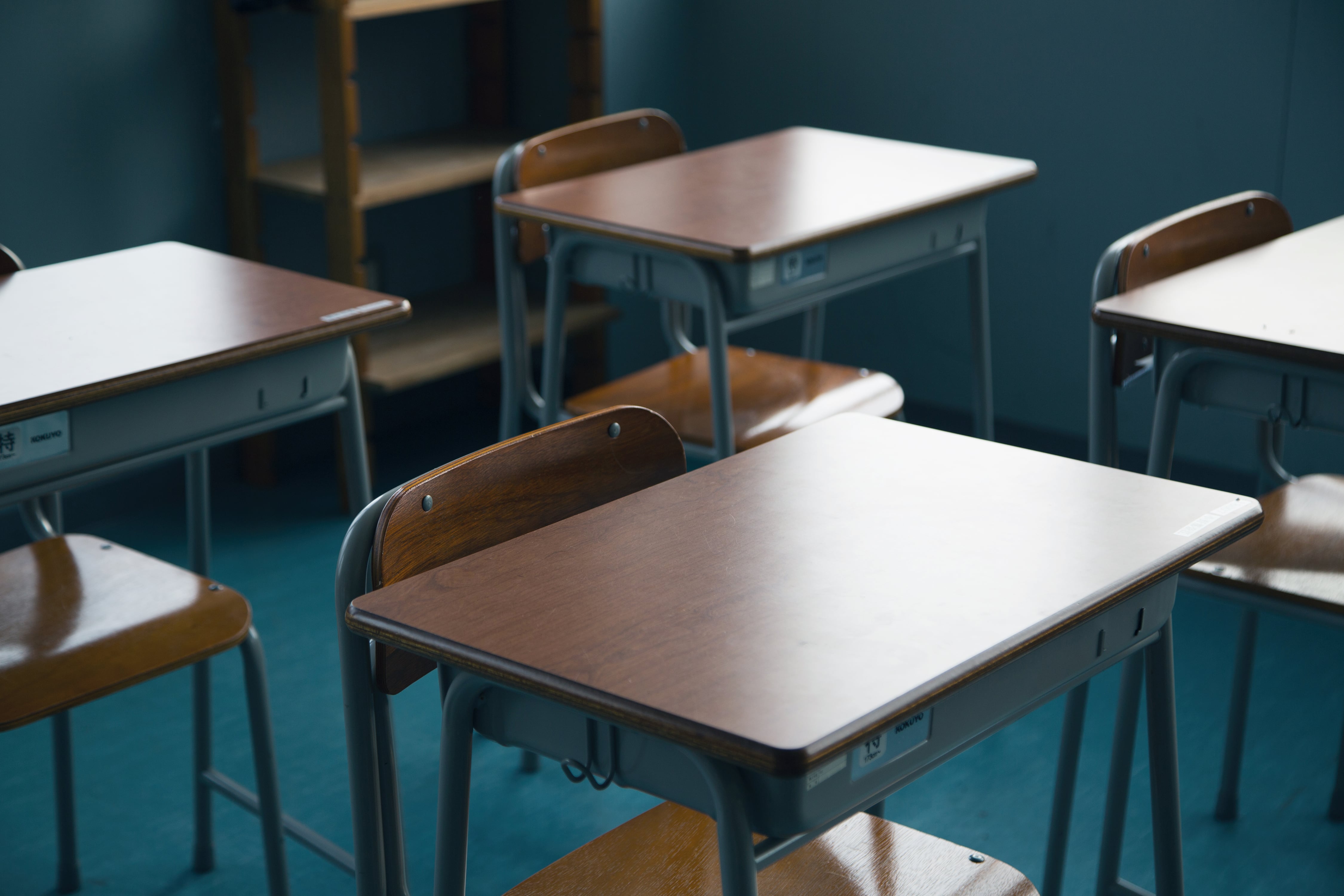 An empty classroom with a handful of desks and chairs.