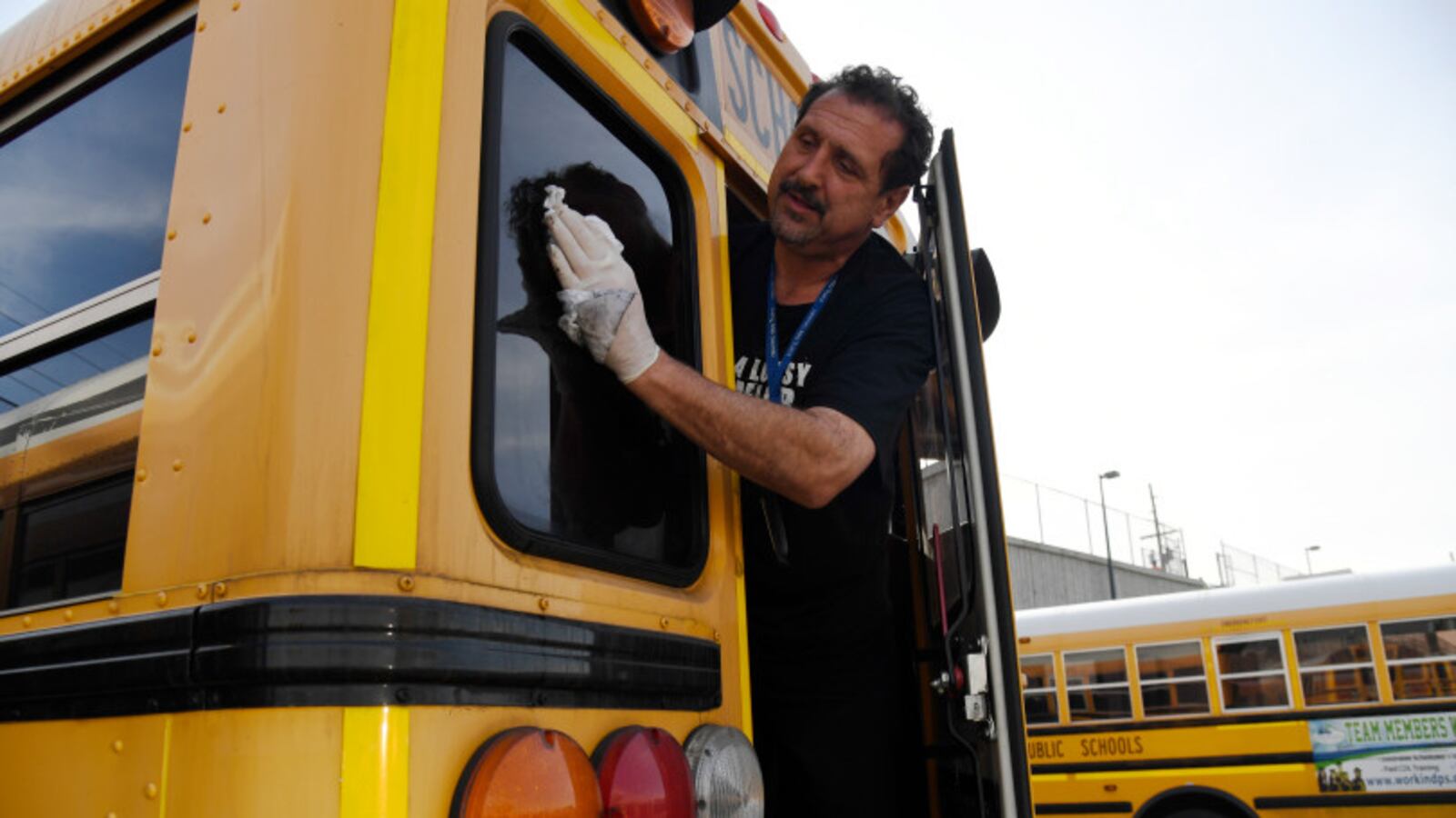 Paraprofessional Ben Johnson washes of the back window of a bus at the Denver Public Schools Hilltop Terminal November 10, 2017.
