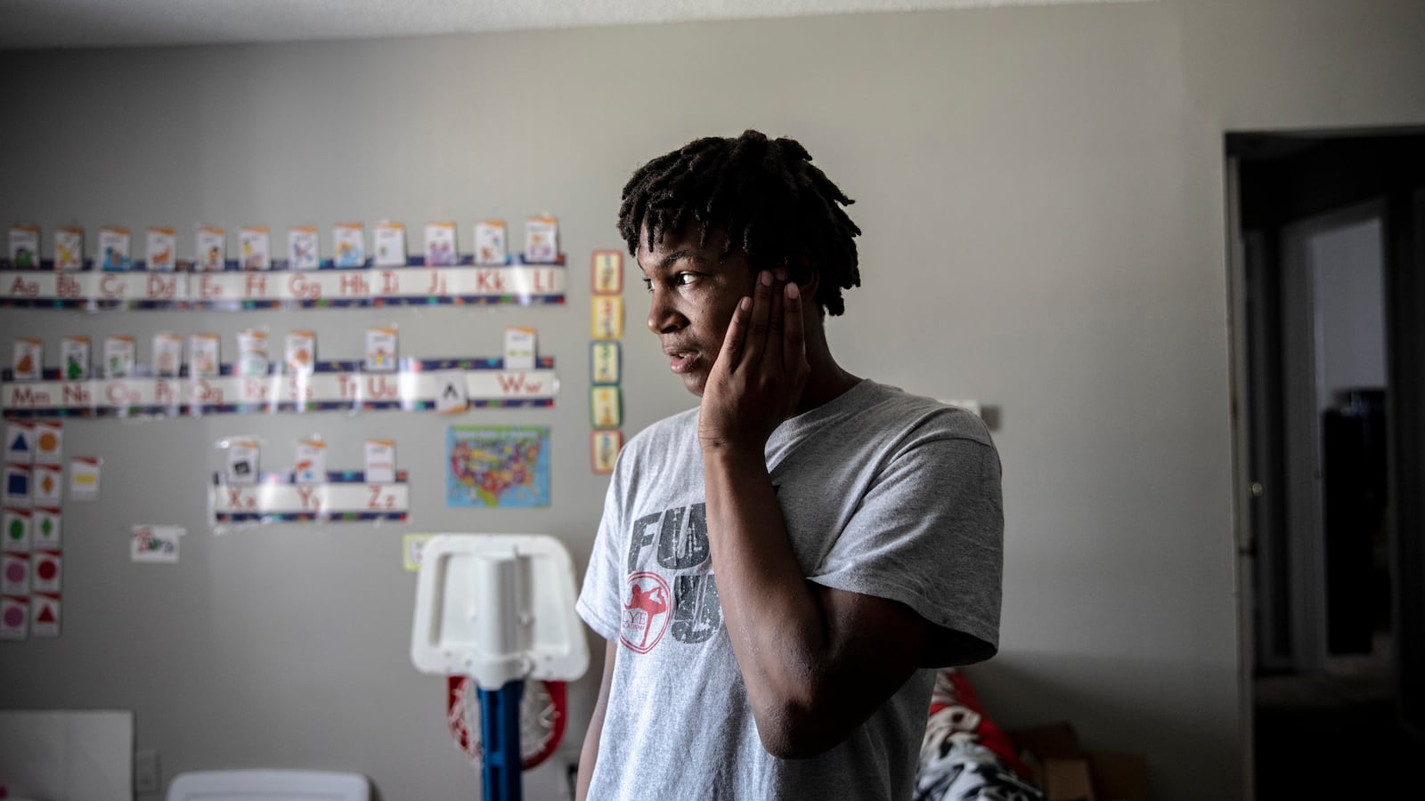 MEMPHIS, TN - March 16, 2021: Jalan Clemmons, a freshman at Hamilton High School, stands in his living room while at home during a virtual school day. His mother, Anna Nuby, works from home and he also lives with his 2-year-old brother Kobi.
