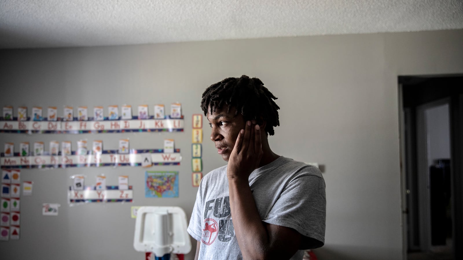 MEMPHIS, TN - March 16, 2021: Jalan Clemmons, a freshman at Hamilton High School, stands in his living room while at home during a virtual school day. His mother, Anna Nuby, works from home and he also lives with his 2-year-old brother Kobi.