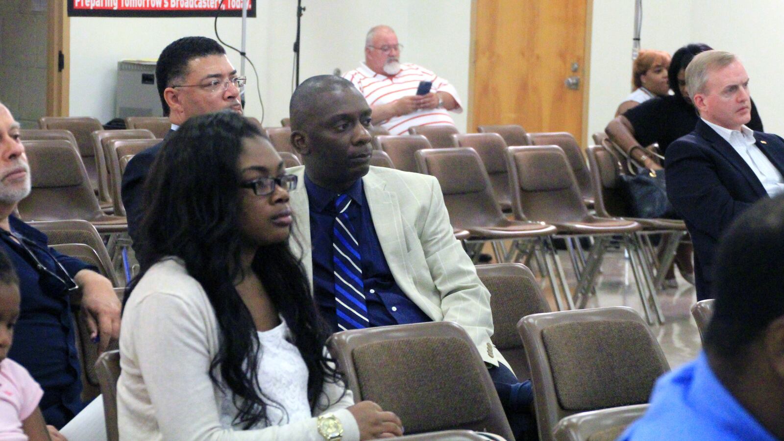 Tommie Henderson, executive director of the New Consortium of Law and Business, listens as district school board members discuss the future of the school.