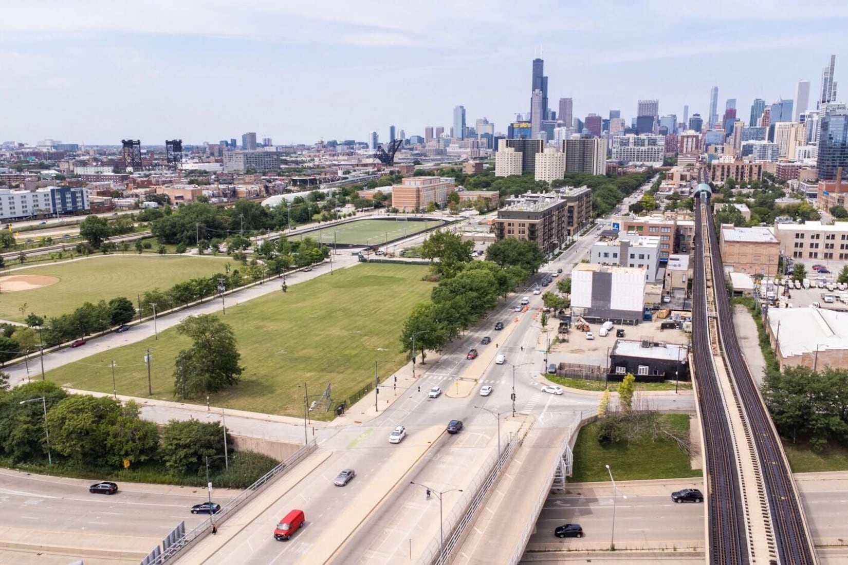 Overhead view of vacant lot with highways and roads in the foreground and the Chicago skyline in the background.
