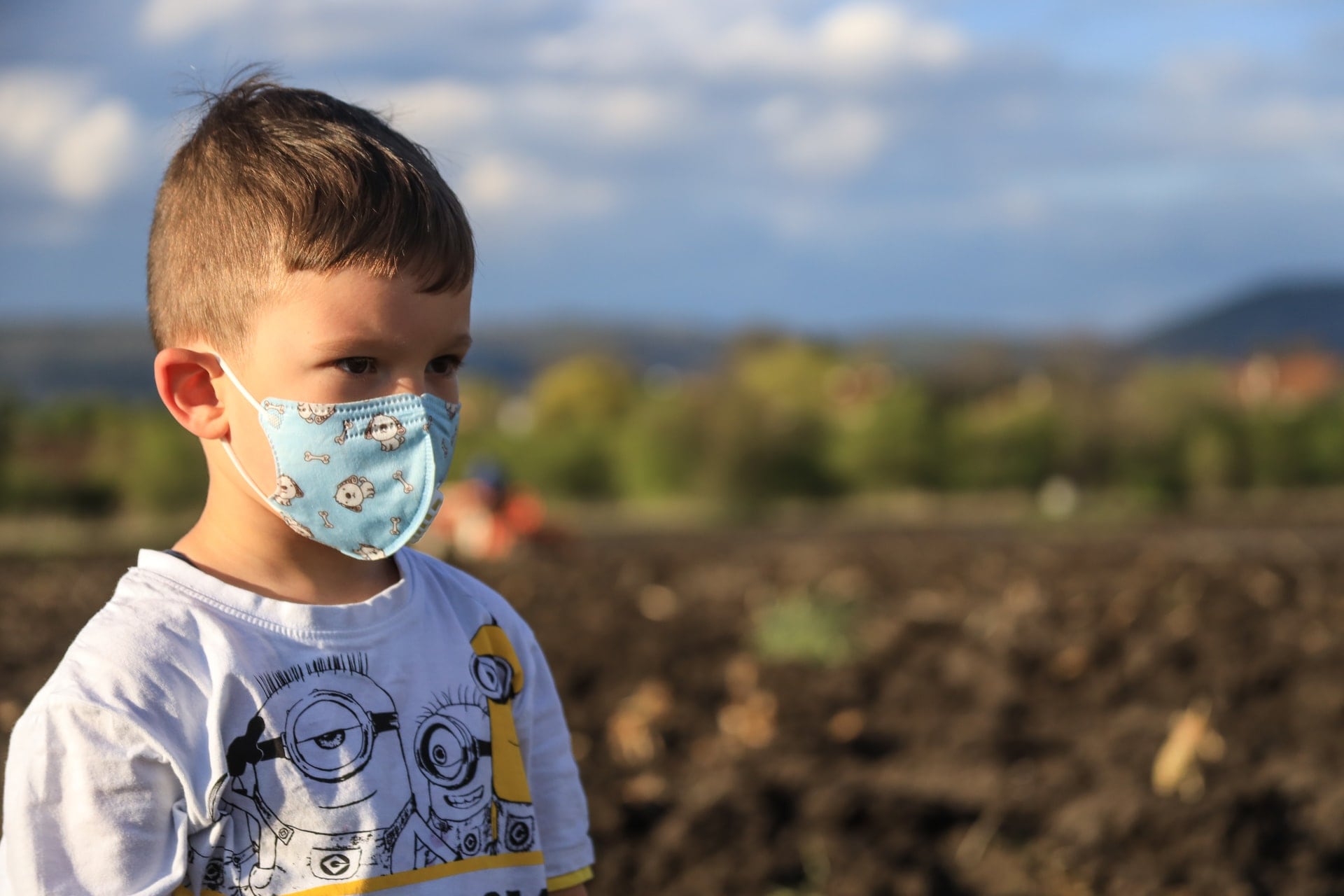 Young boy wearing a protective fabric face mask.